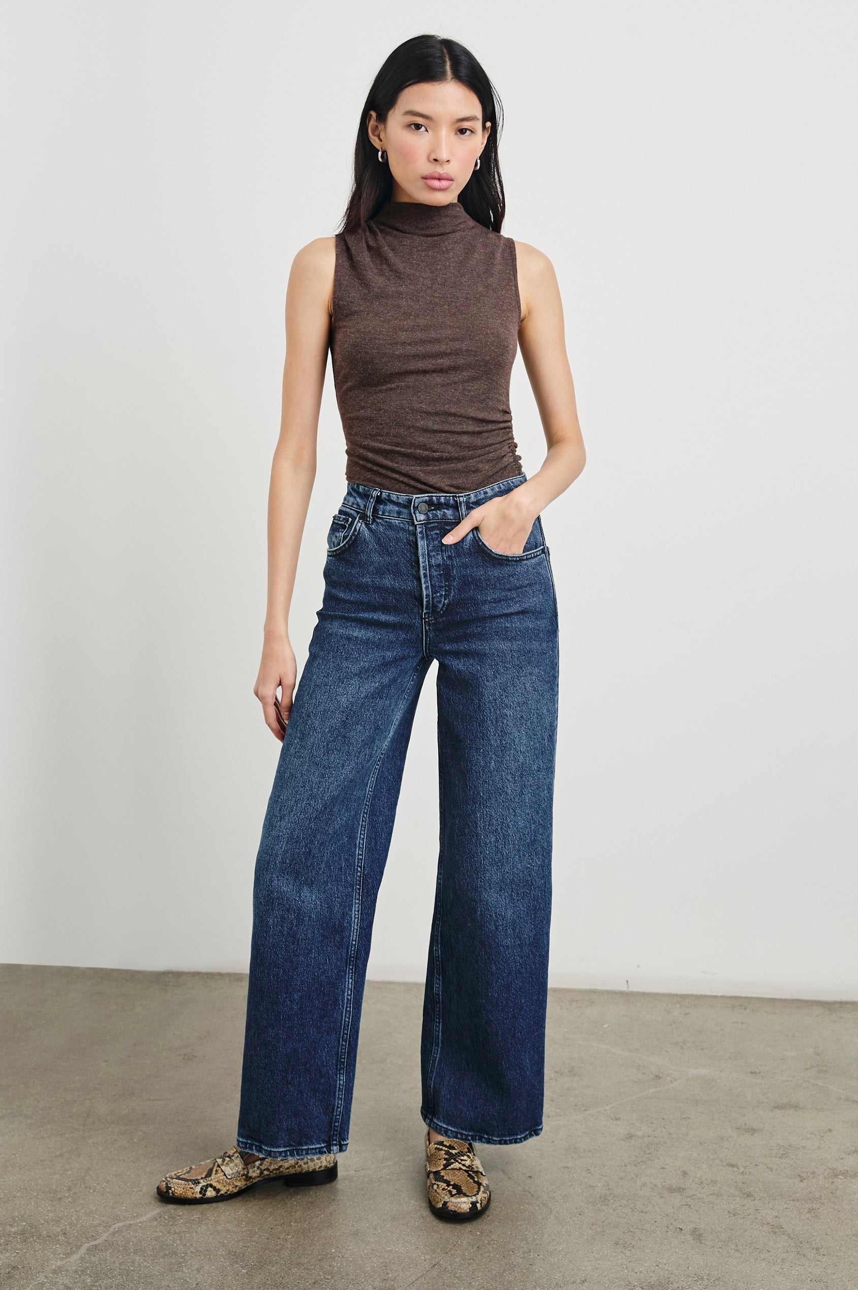 Christen Sleeveless Top with a Mock Neck and Ruching Along One Side Seam in Heather Brown Colorway - Front Full Body View Featured on Model