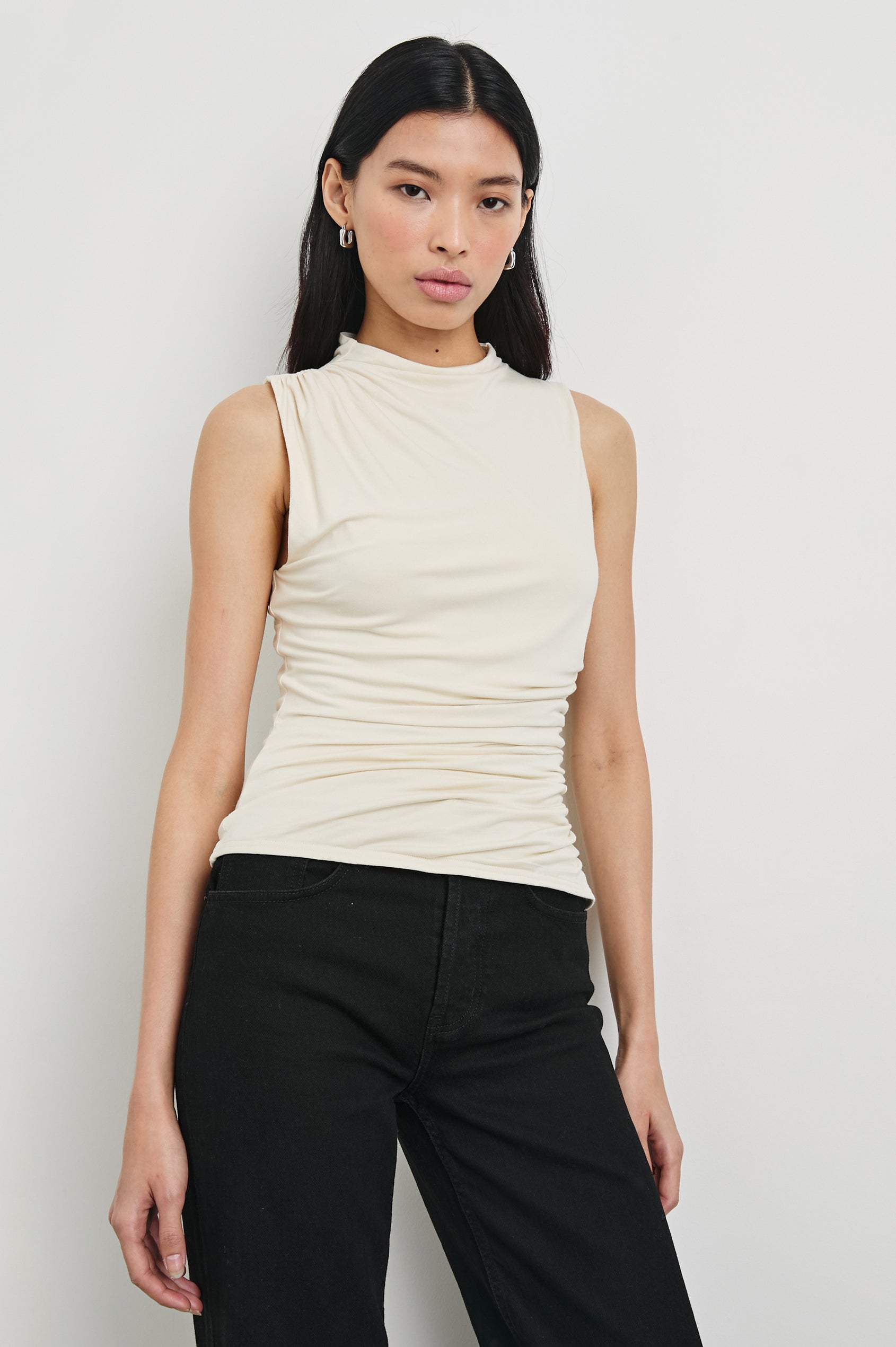 Christen Sleeveless Top with a Mock Neck and Ruching Along One Side Seam in Ivory Colorway - Front View Featured on Model