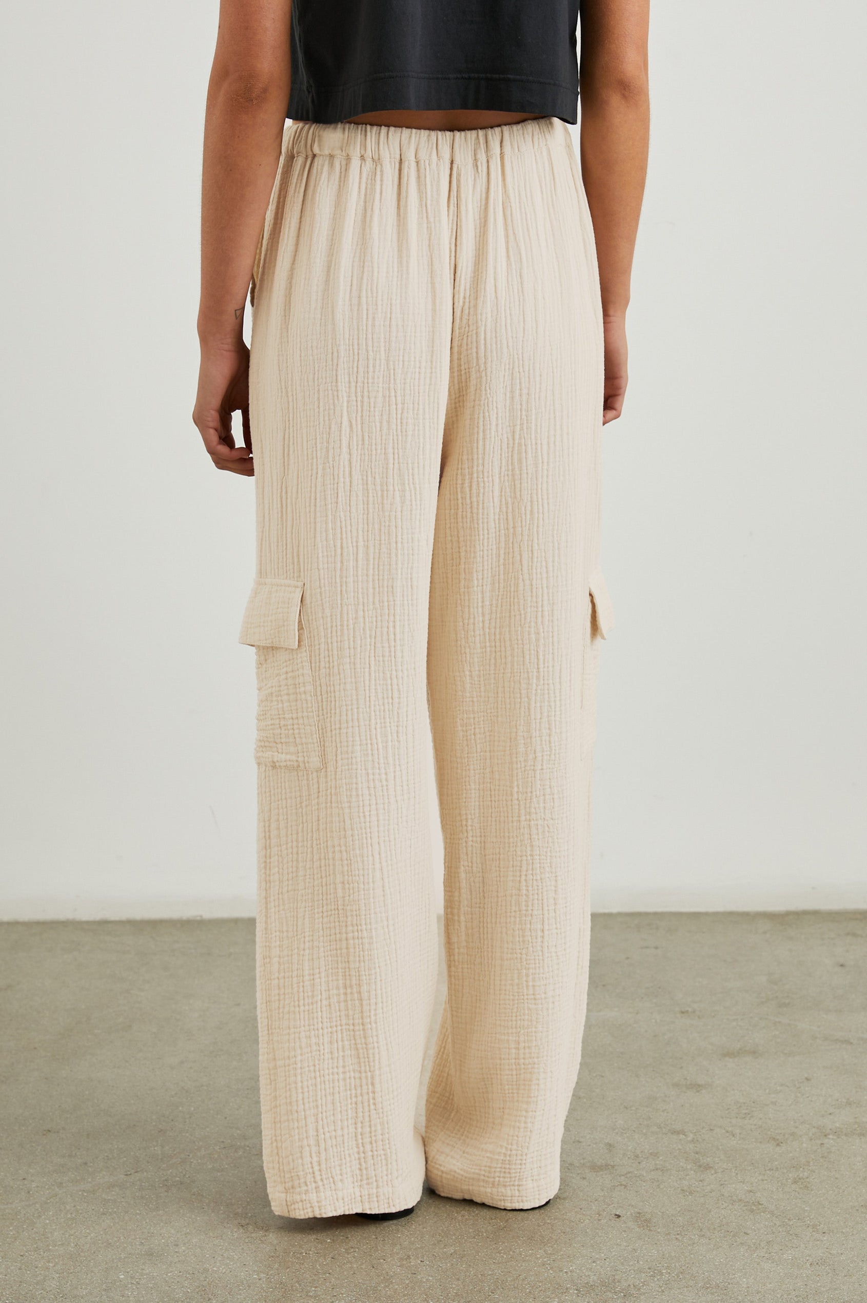 Christiano Pants with a Drawstring Waist, Two Front Pockets and Two Flap Side Pockets in Flax Colorway - Back View Featured on Model  