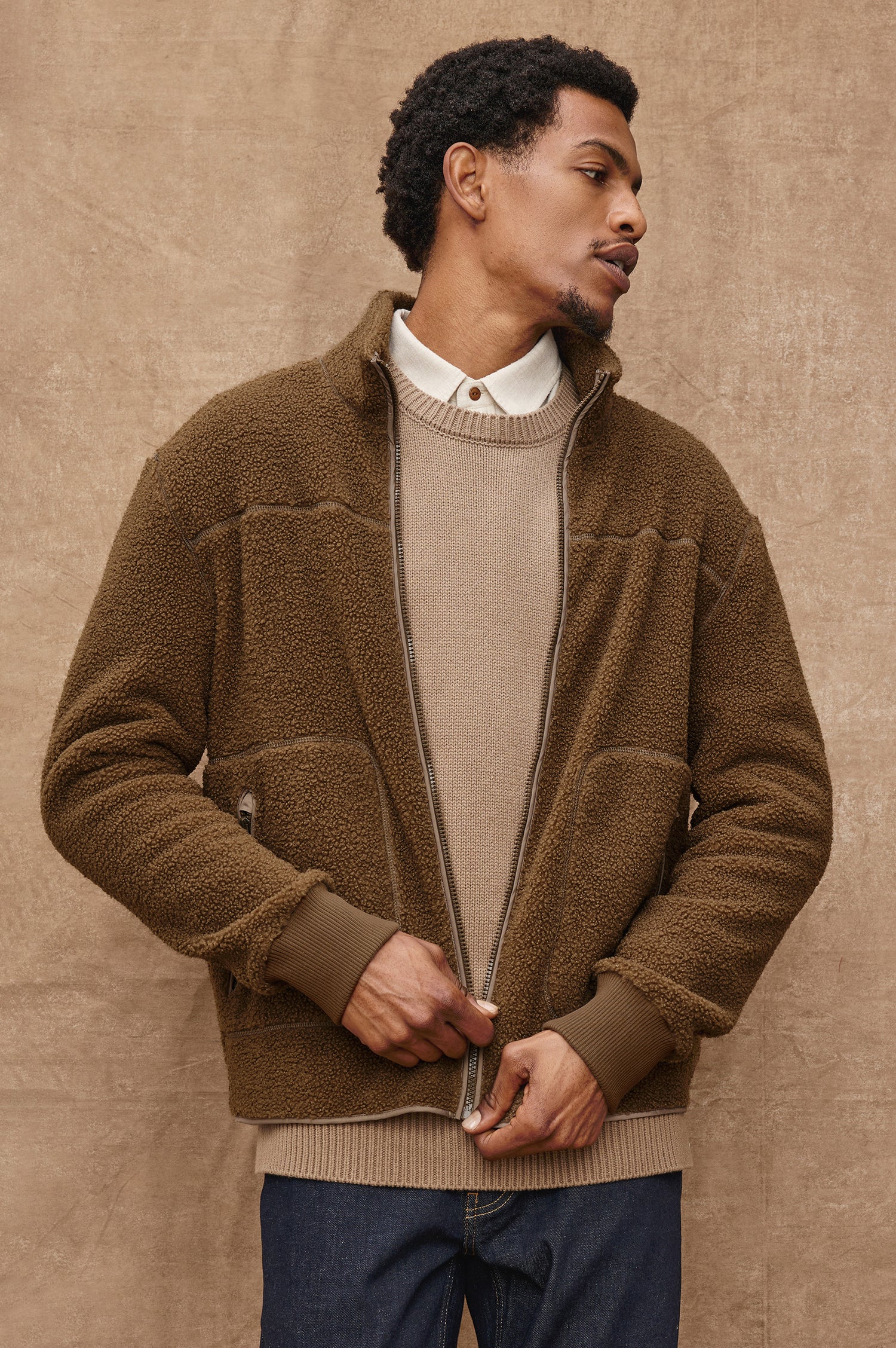 The Clark is a zip front brushed back polar fleece and details include contrast stitching, two zipper pockets, and contrast  grey ribbed cuffs in Lichen colorway. Front view featured on model.