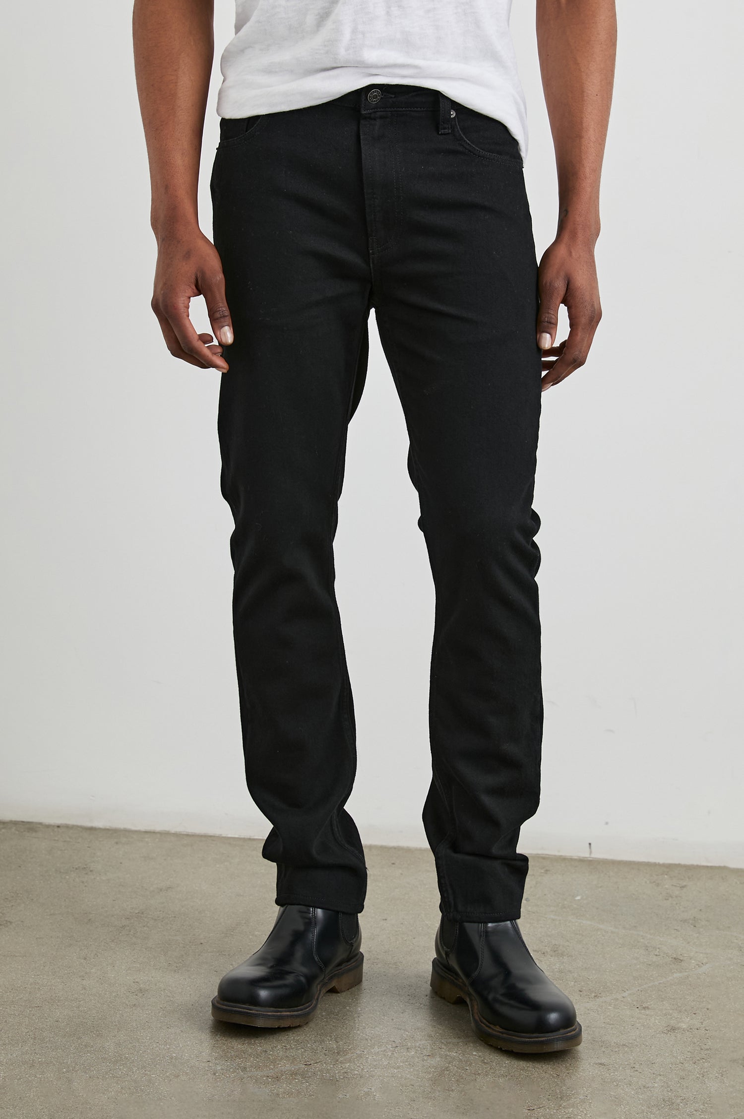 Men's Clayton slim-straight leg jeans in a solid Dark Black denim wash. Close up view of model featured.