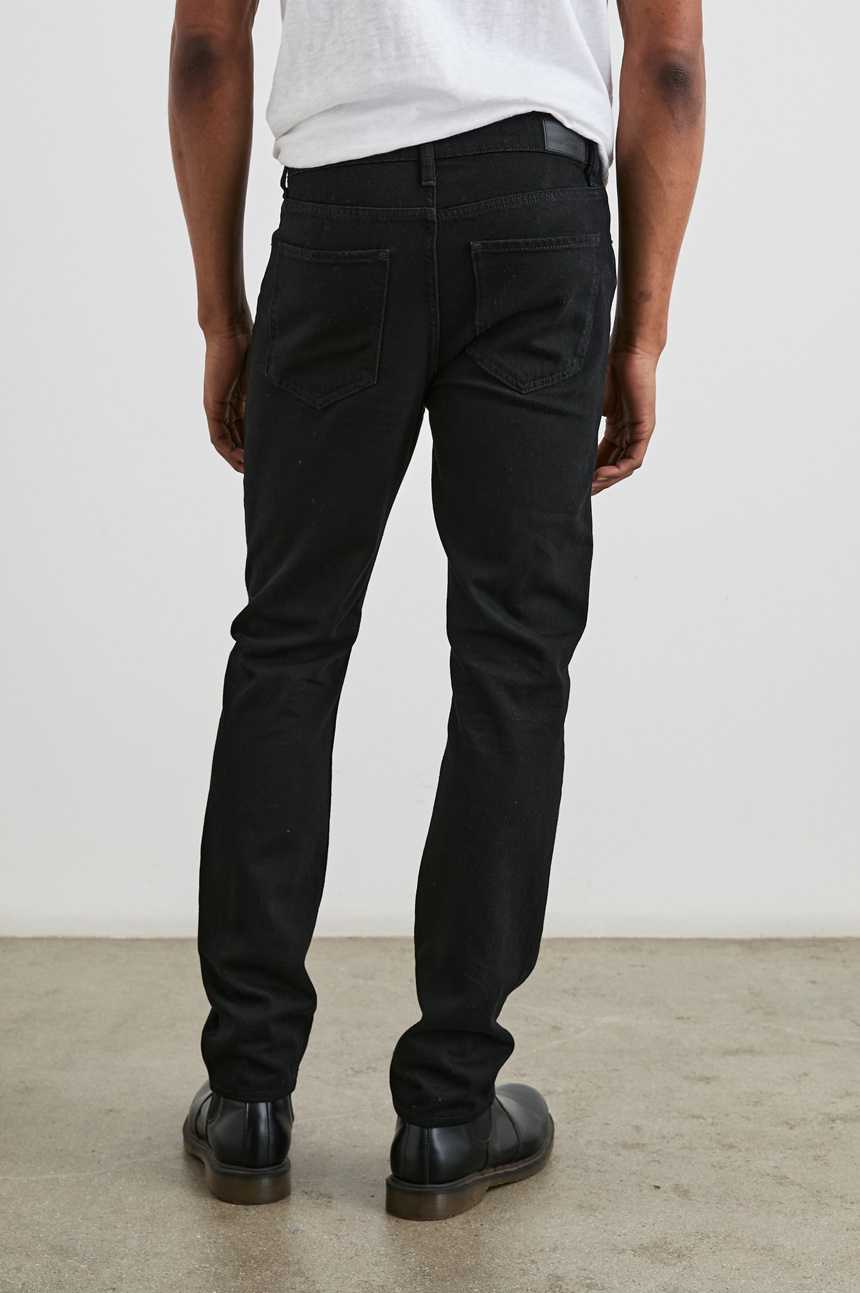 Clayton Slim Straight Jeans with Belt Loops, Two Front Pockets plus a Coin Pocket and Two Back Patch Pockets in Dark Black Colorway - Back View Featured on Model