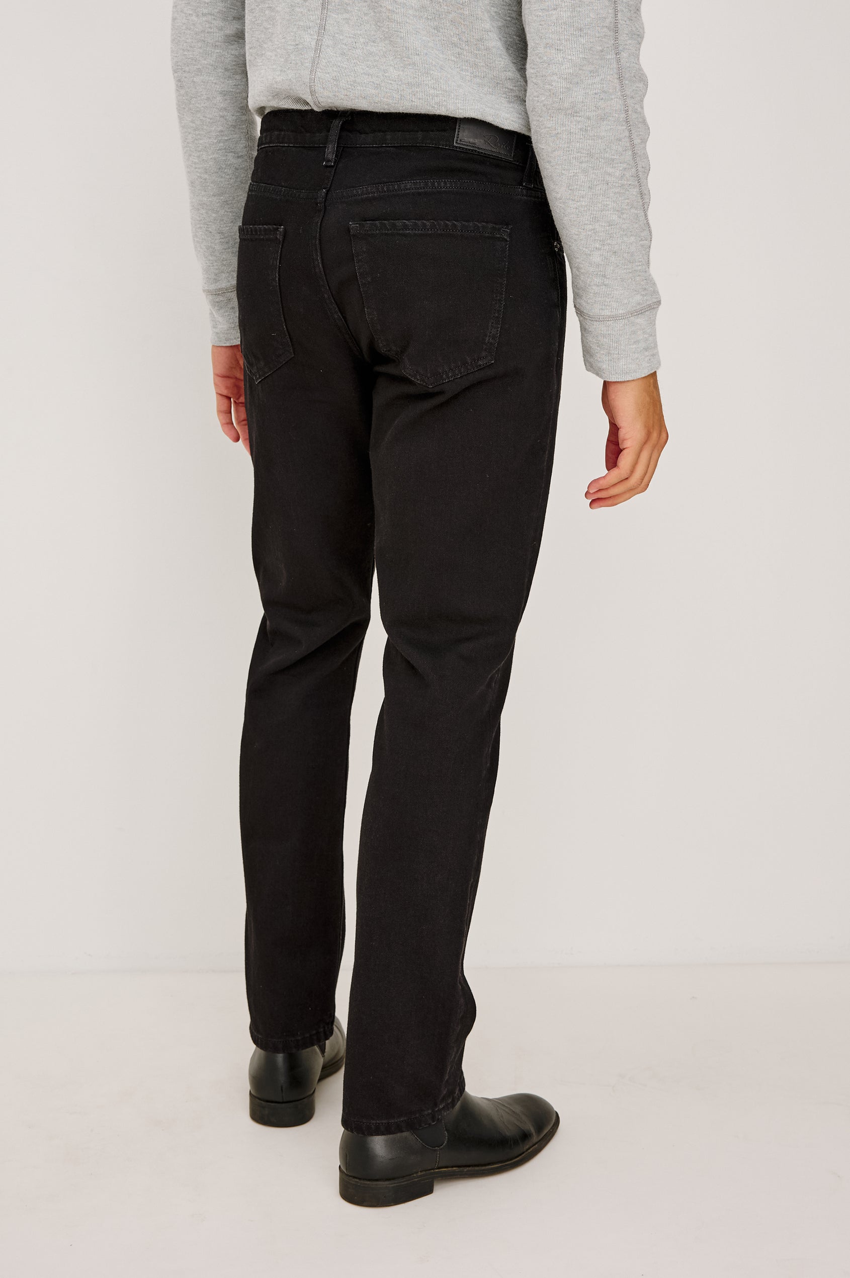 Clayton Slim Straight Jean With 5-Pocket Styling, Belt Loops, and Front Zip-Fly in Dark Black Colorway - Lower Body Back View Featured on Model