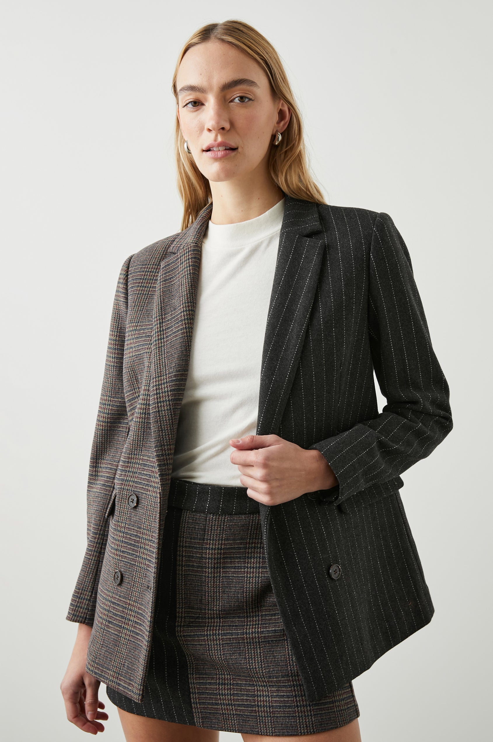 Cody Double-Breasted Blazer with Two Button Closure, Two Front Flap Pockets, and Four-Button Cuffs in Pinstripe Plaid Mix Colorway, the Right Half is a Plaid in Brown, Blue and Red, the left half is White pinstripe on Black - Front View Featured on Model