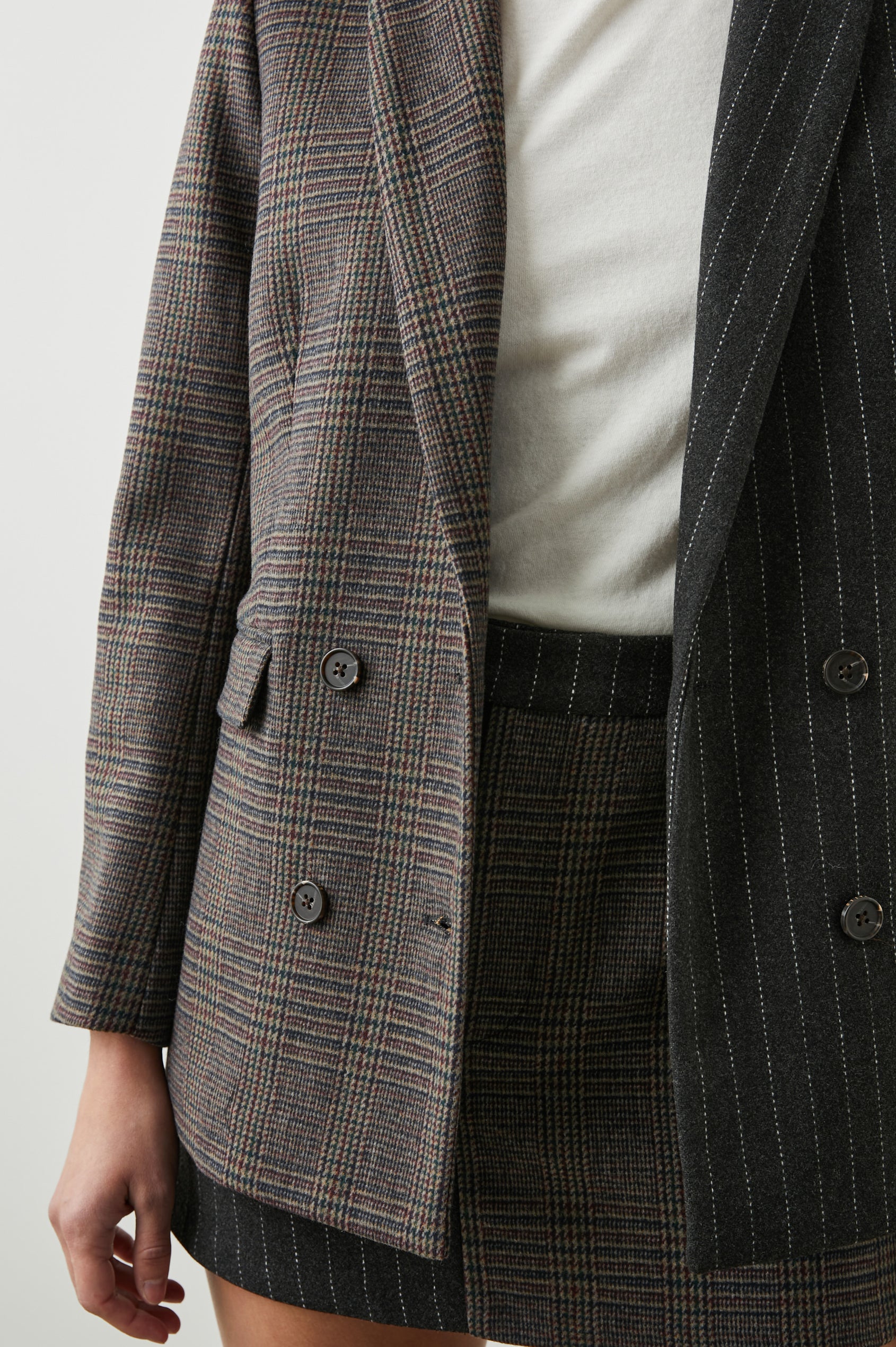 Cody Double-Breasted Blazer with Two Button Closure, Two Front Flap Pockets, and Four-Button Cuffs in Pinstripe Plaid Mix Colorway, the Right Half is a Plaid in Brown, Blue and Red, the left half is White pinstripe on Black - Front View Featured on Model