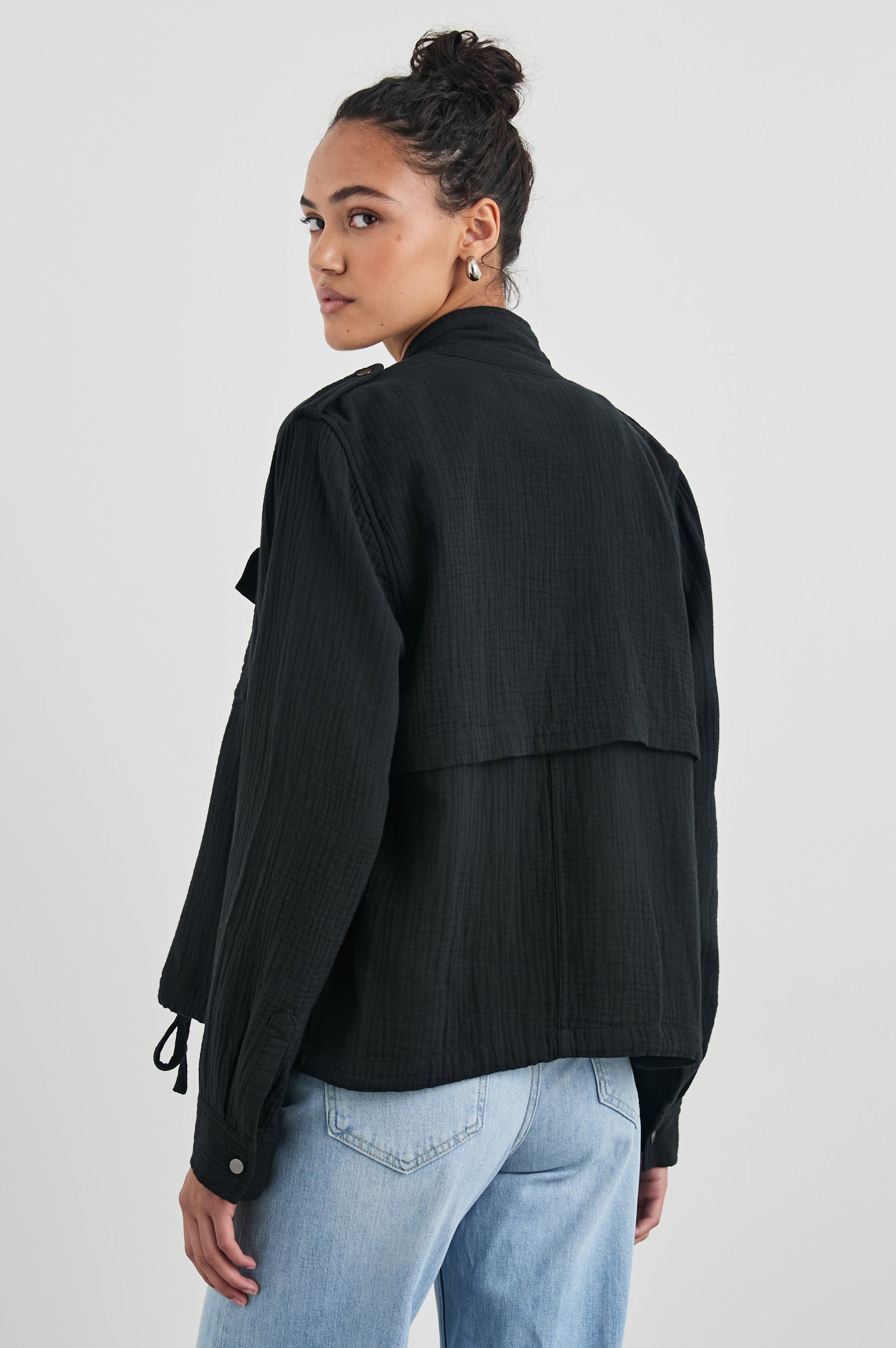 Collins Jacket with Zip and Snap Closure, Two Chest Snap Flap Pockets, Toggle Drawstring Hem, Snap Shoulder Straps and a Breathable Back Flap in Gauze Black Colorway - Back View Featured on Model