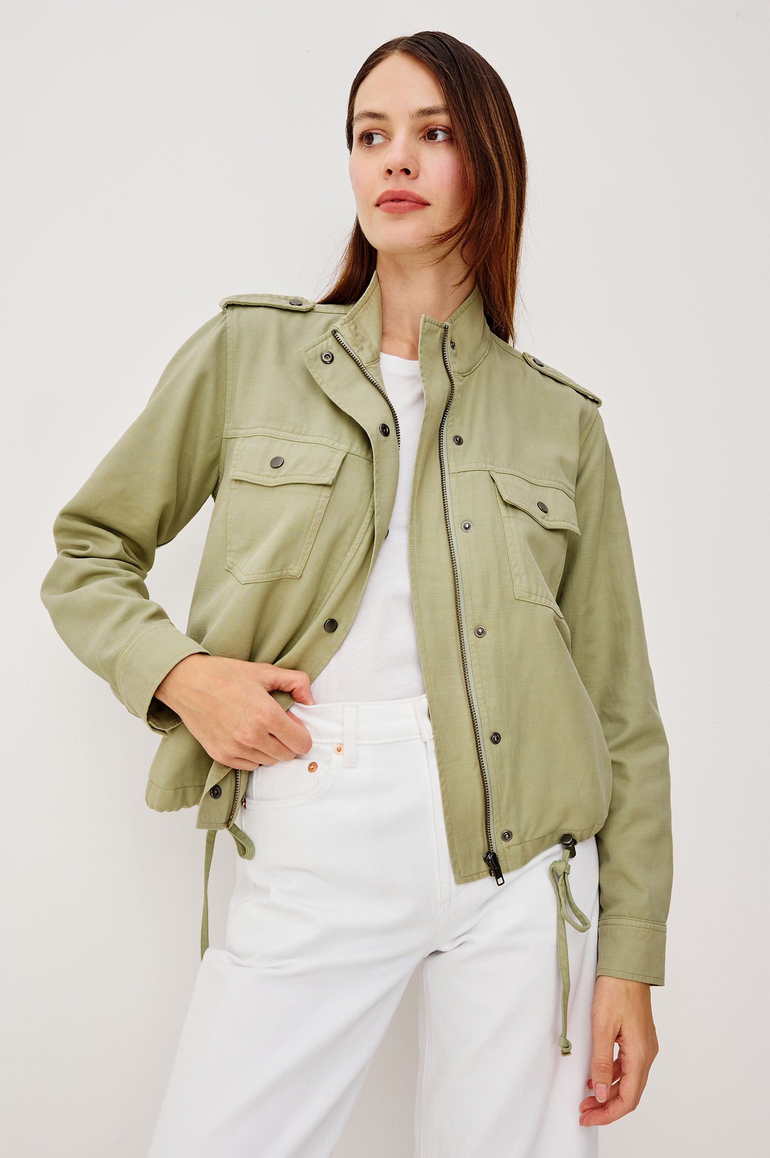 Collins Miitary Inspired Jacket With Shoulder Epaluettes Stand Collar Front Snap Buttons Double Chest Pockets Long Sleeves in Vintage Sage Colorway - Upper Body Front View Featuered on Model