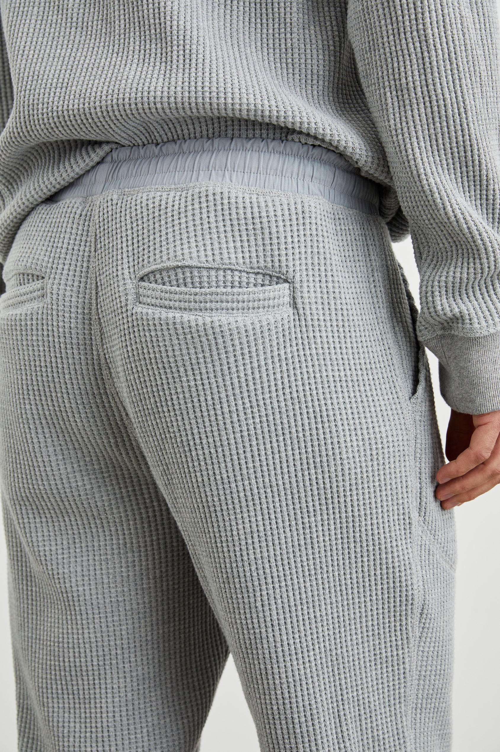 Cooper Waffle Thermal Pants with an Elastic Drawstring Waist, Two Teardrop Front Pockets, Two Back Welt Pockets, Reinforced Knee Patches and Elastic Cuffs in Heather Grey Colorway - Back View Featured on Model