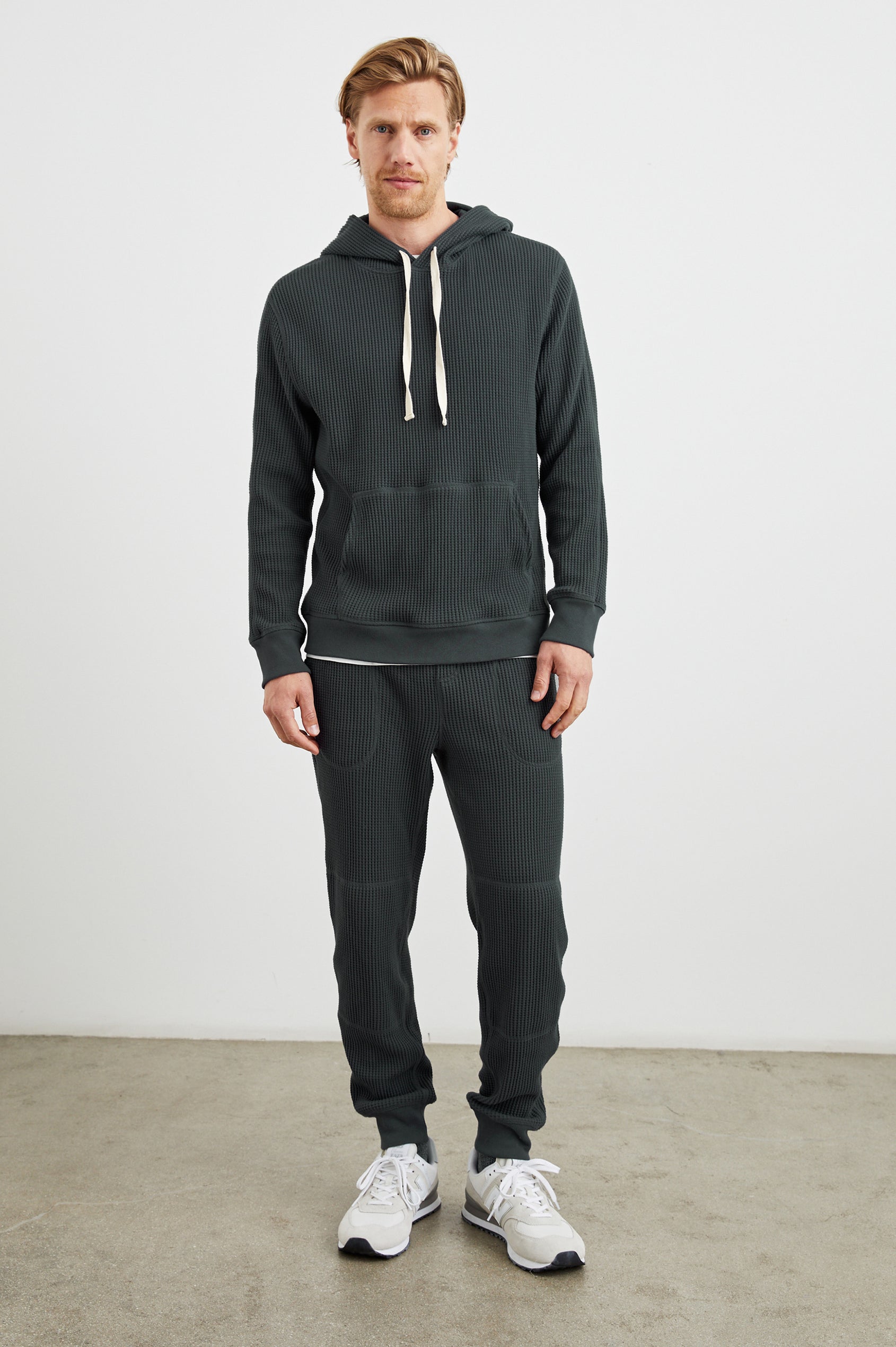 Cooper Waffle Thermal Pants with an Elastic Drawstring Waist, Two Teardrop Front Pockets, Two Back Welt Pockets, Reinforced Knee Patches and Elastic Cuffs in Ink Colorway - Front Full Body View Featured on Model