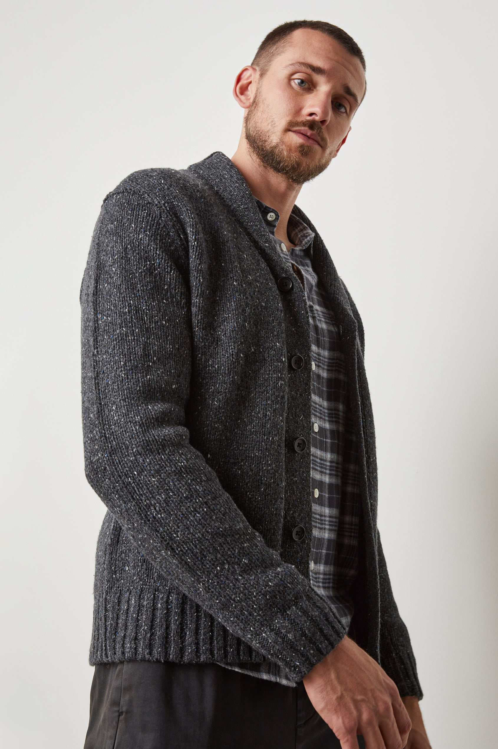 Corden Long-Sleeve Cardigan with Button Closure, a Shawl Collar and Ribbed Trim in Constellation Colorway, White and Blue Speckles on Dark Grey - Side View Featured on Model