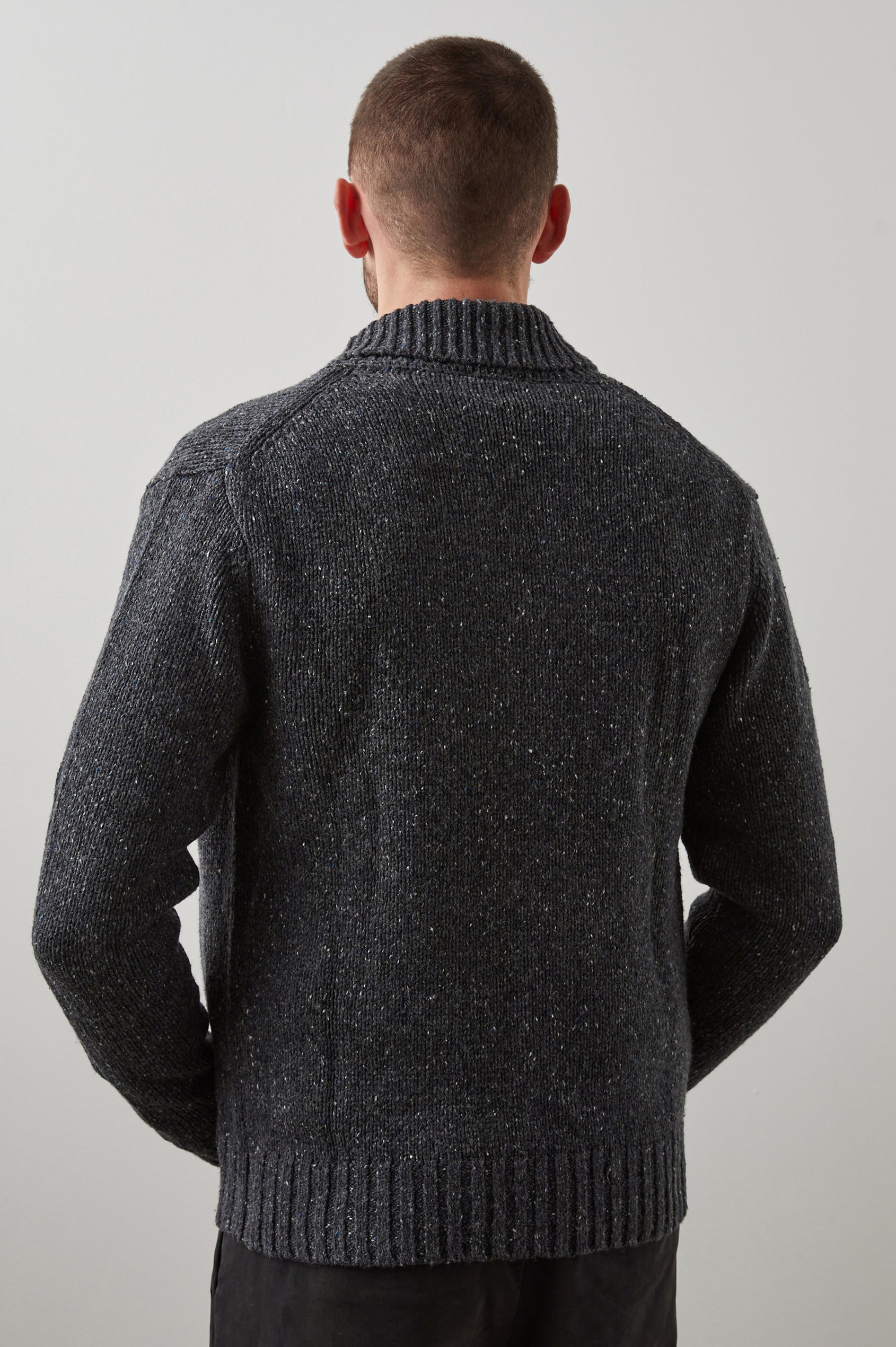 Corden Long-Sleeve Cardigan with Button Closure, a Shawl Collar and Ribbed Trim in Constellation Colorway, White and Blue Speckles on Dark Grey - Back View Featured on Model
