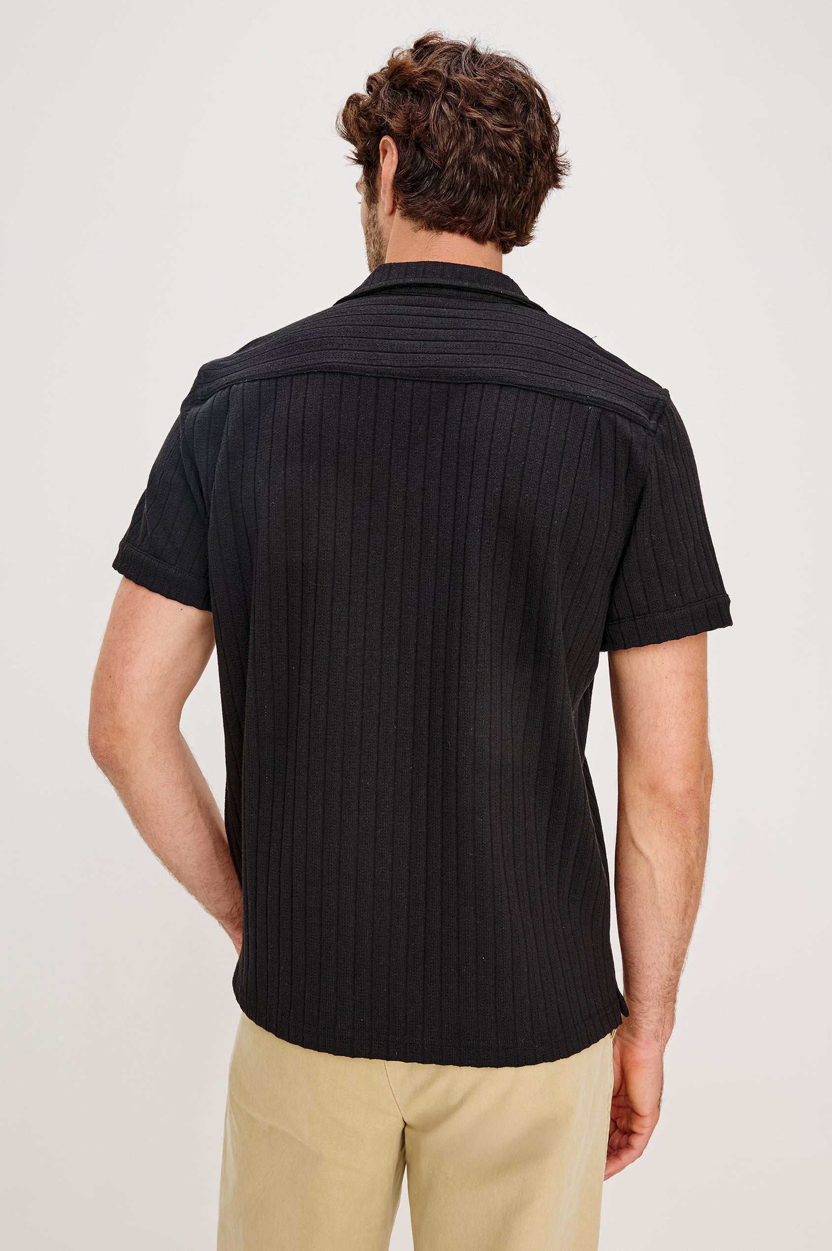 Corrin is a short sleeve camp style shirt with a notched lapel in Black colorway. Back view featured on model.