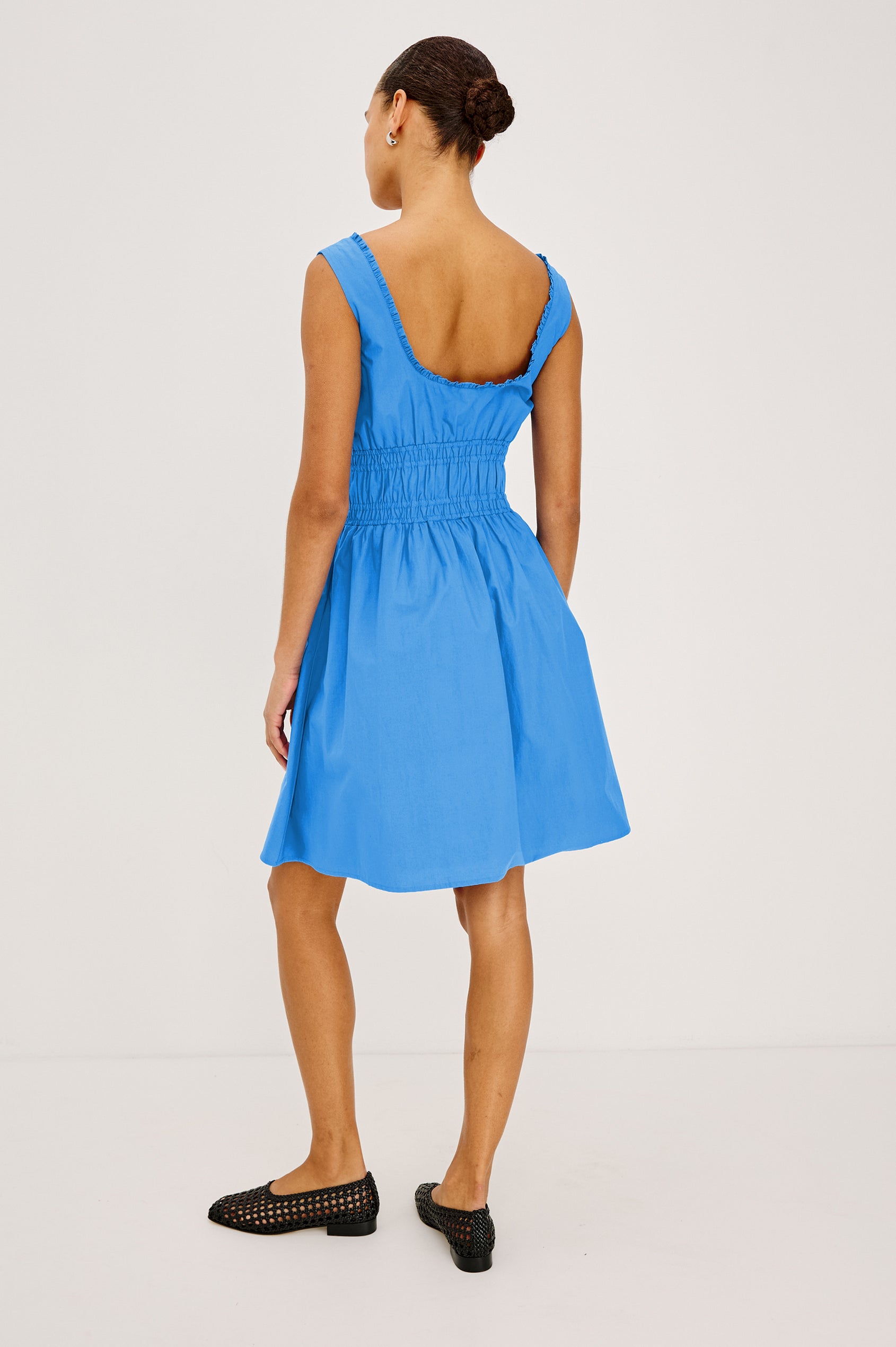 Cosette Mini Dress in Cotton Poplin With Square Neckline, Center Bust Ties, Ruffle Trim, and Smocked Waist in Harbor Blue Colorway - Full Body Back View Featured on Model