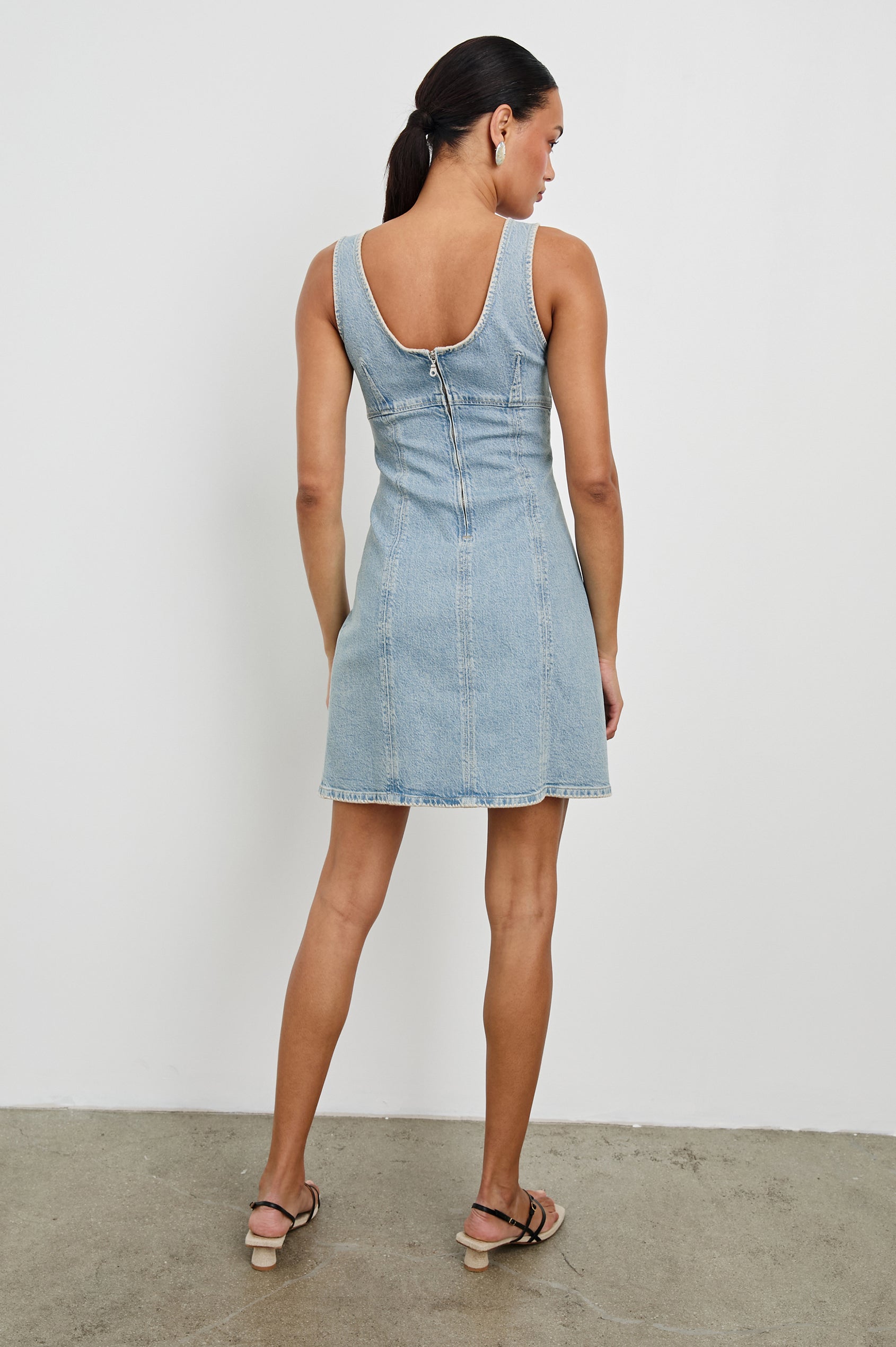 Cove Denim Tank Dress with a Scoop Neck, Empire Bust, Back Exposed Zipper Closure, A-line and Above-Knee Length in Capri Colorway.  Full Body Back View Shown on Model.
