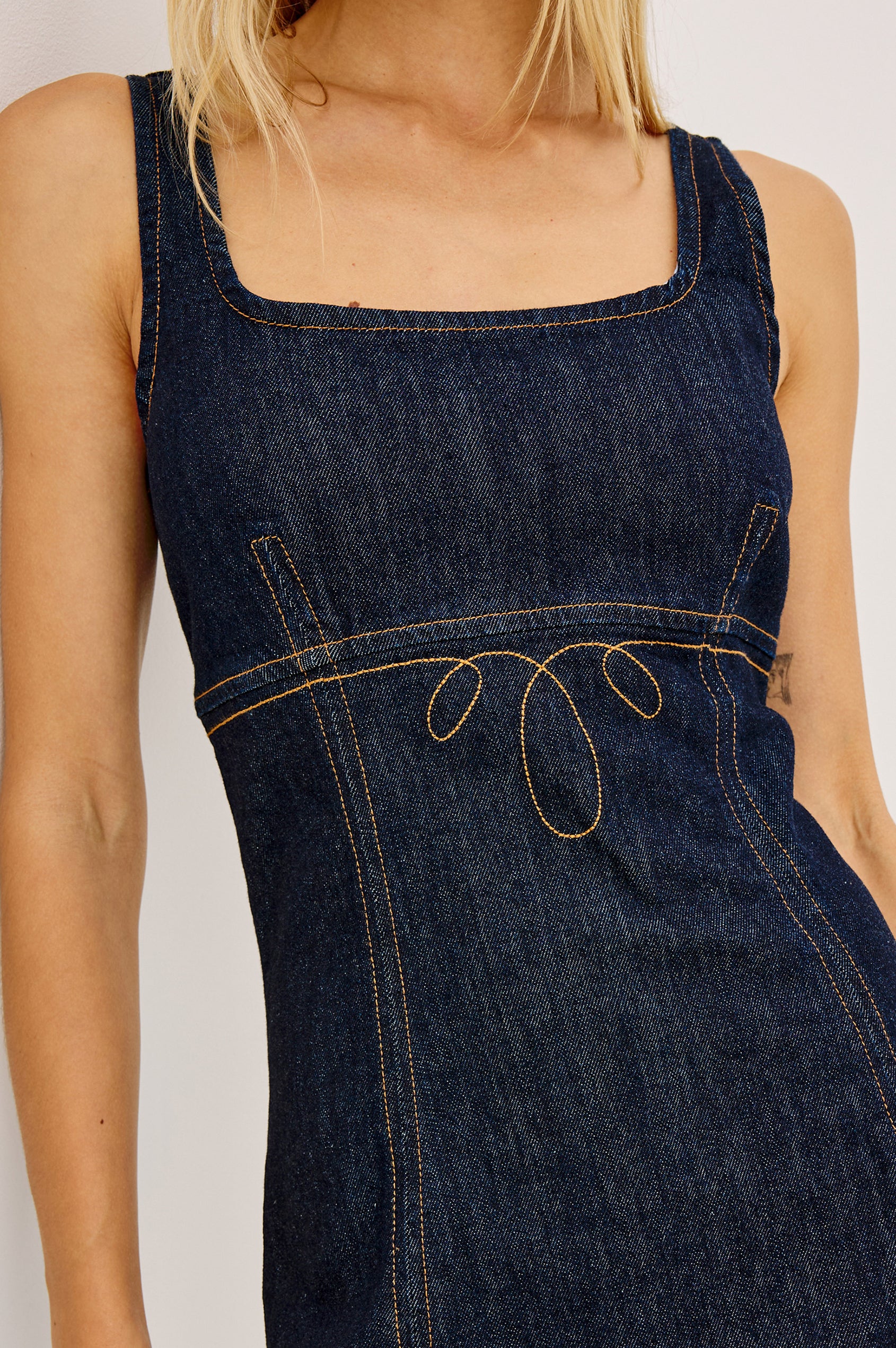 Cove Mini Dress in Comfort-Stretch Denim With A-Line Silhouette, Empire Waist, Contrast Topstitching, and Side Pockets in Midnight Blues Colorway - Mid Body Front View Featured on Model