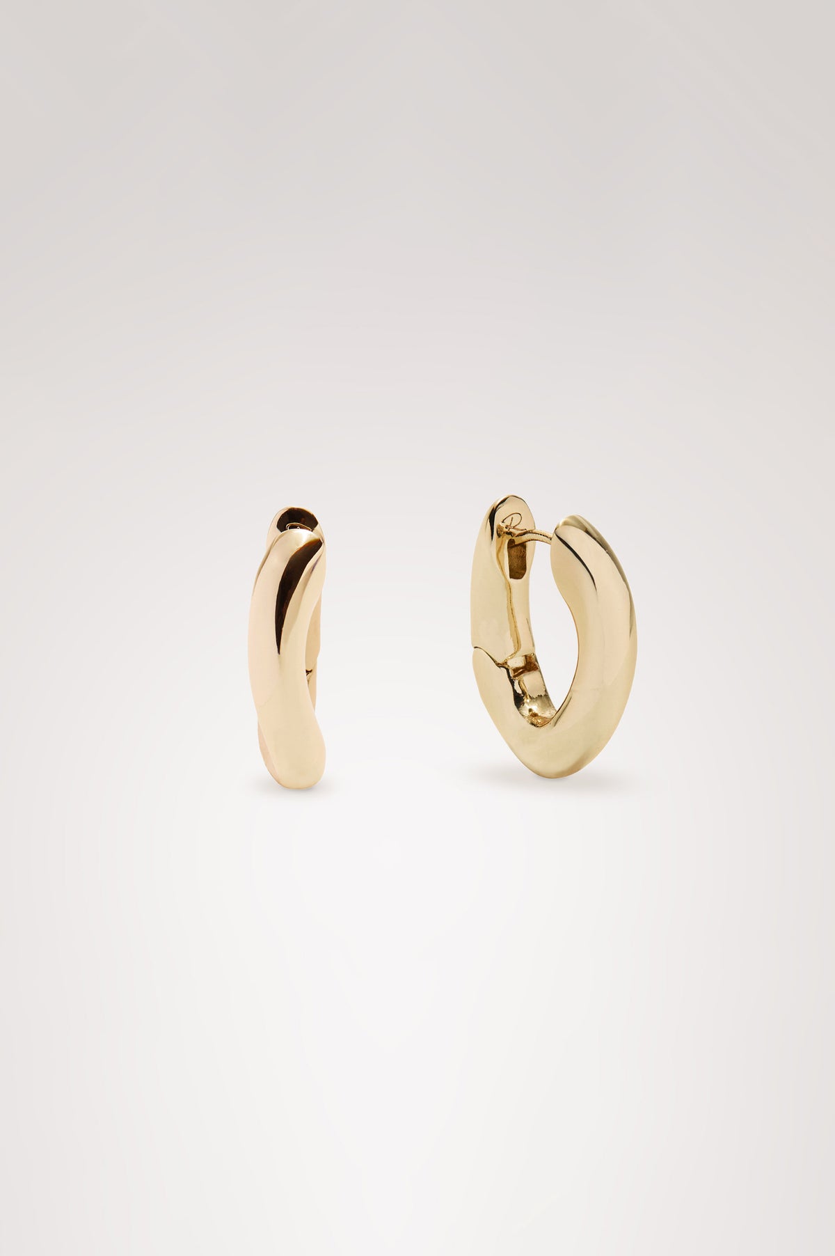Curved Hoop Earrings With Hinged-Back Closure, Sculptural Shape, and Interior Rails Embossed Logo in Gold Colorway - Flat Lay Product View Featured