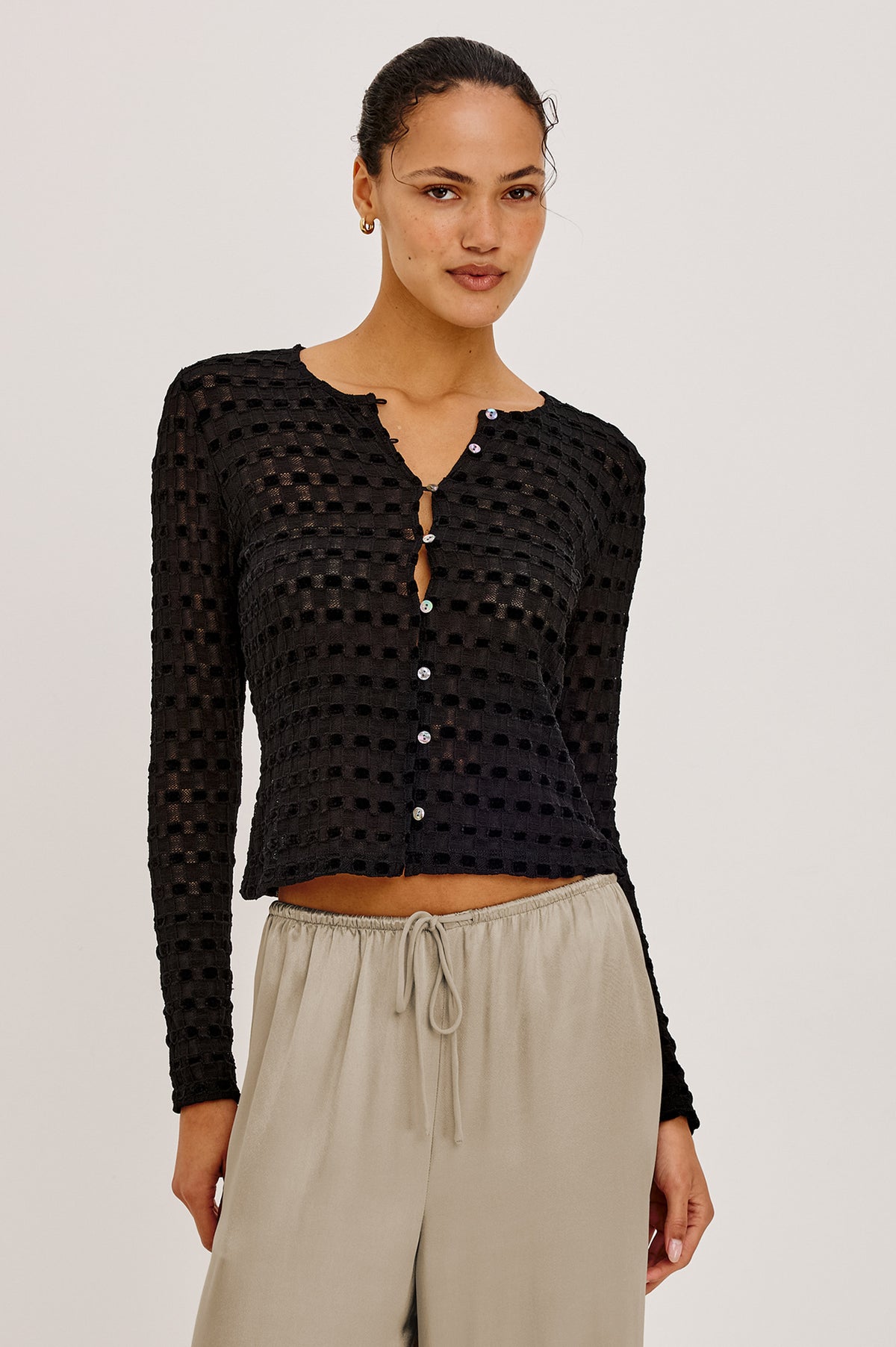 Cyrah Cardigan in Sheer Stretch Lace With Fitted Long Sleeves, and Front Button-and-Loop Closures in Black Checkerboard ColorwayUpper Body Front View Featured on Model.