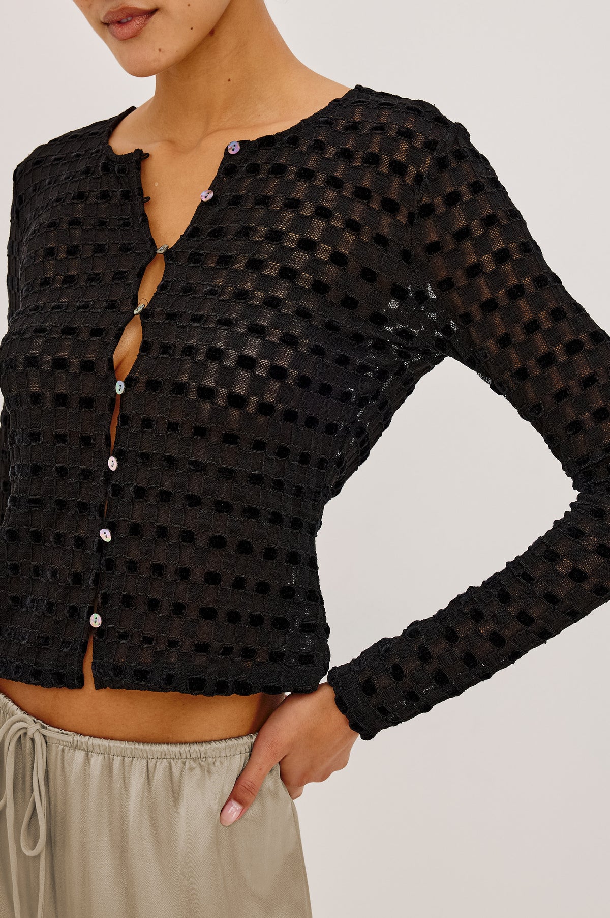 Cyrah Cardigan in Sheer Stretch Lace With Fitted Long Sleeves, and Front Button-and-Loop Closures in Black Checkerboard ColorwayUpper Body Front Detail View Featured on Model.