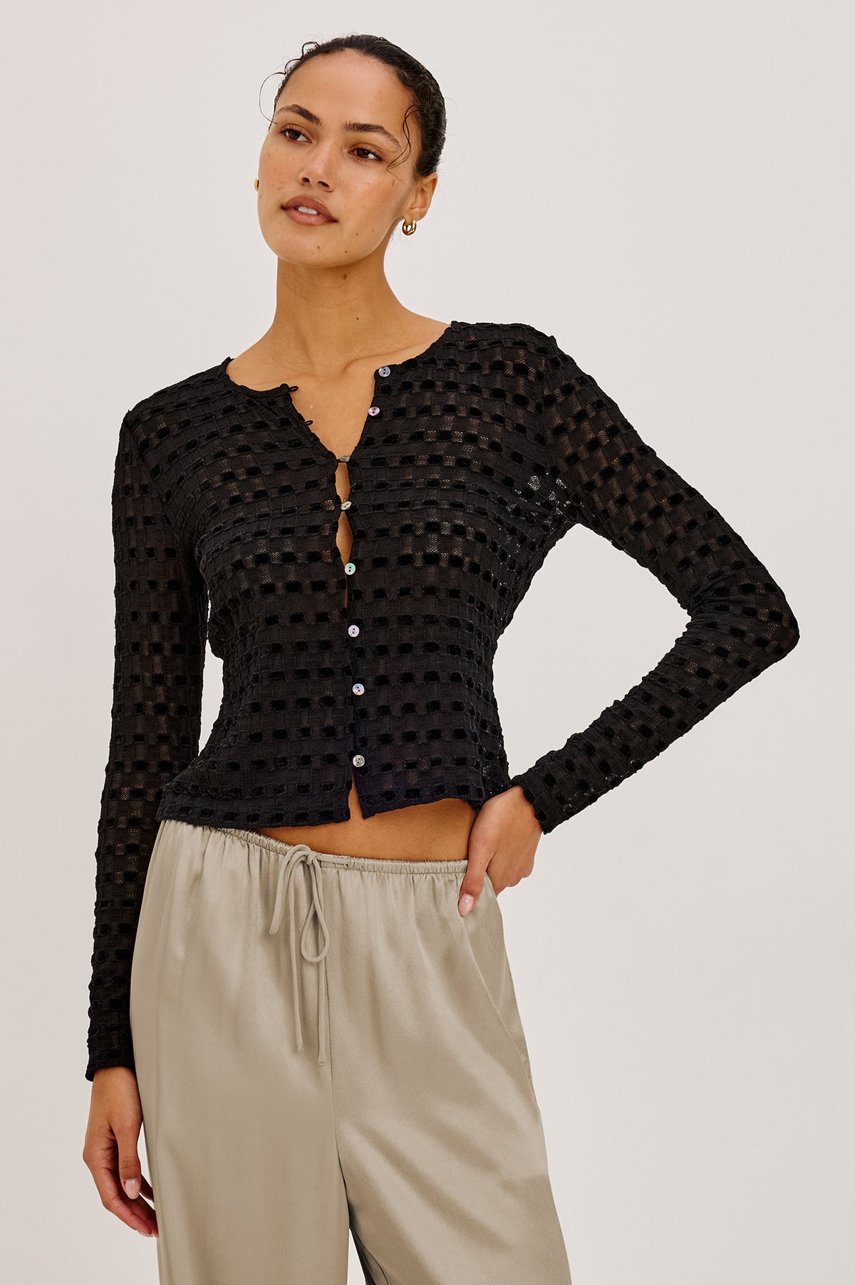 Cyrah Cardigan in Sheer Stretch Lace With Fitted Long Sleeves, and Front Button-and-Loop Closures in Black Checkerboard ColorwayFront View Featured on Model.