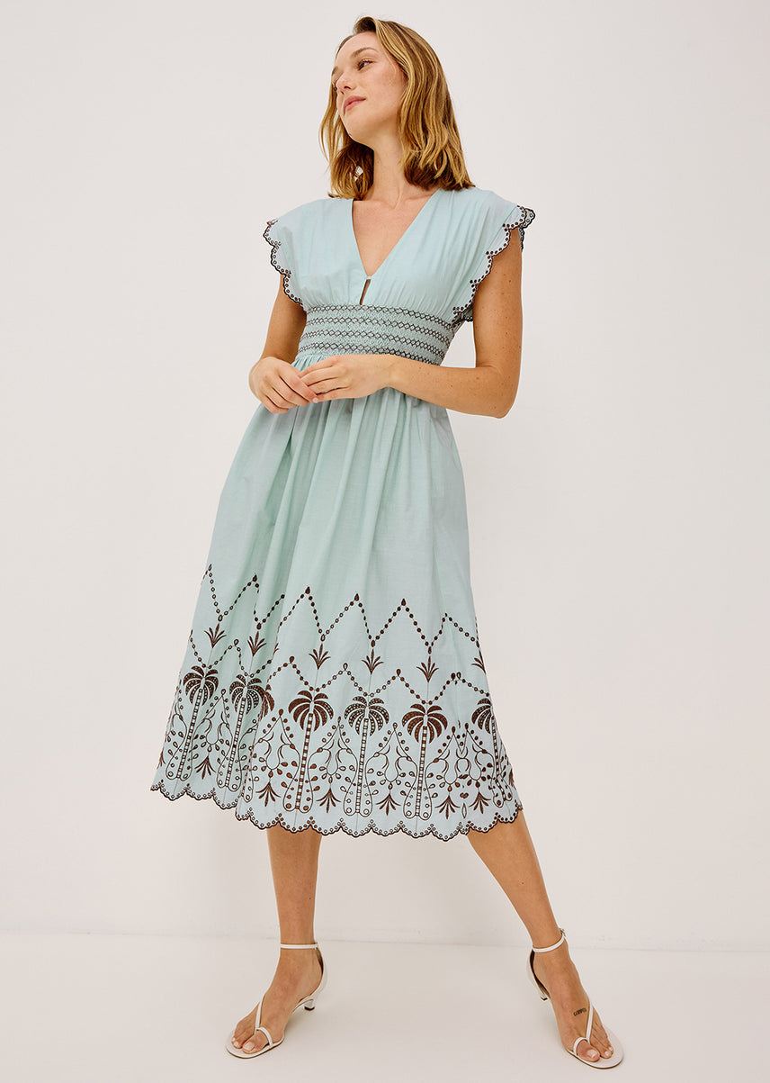Woman wearing a blue midi dress with brown detailing all over
