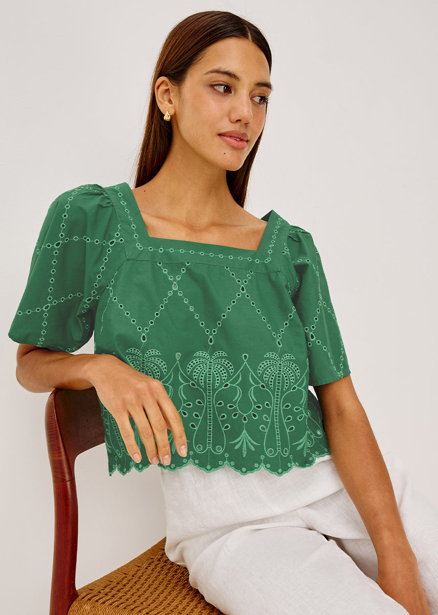 Woman in a green top with white pants