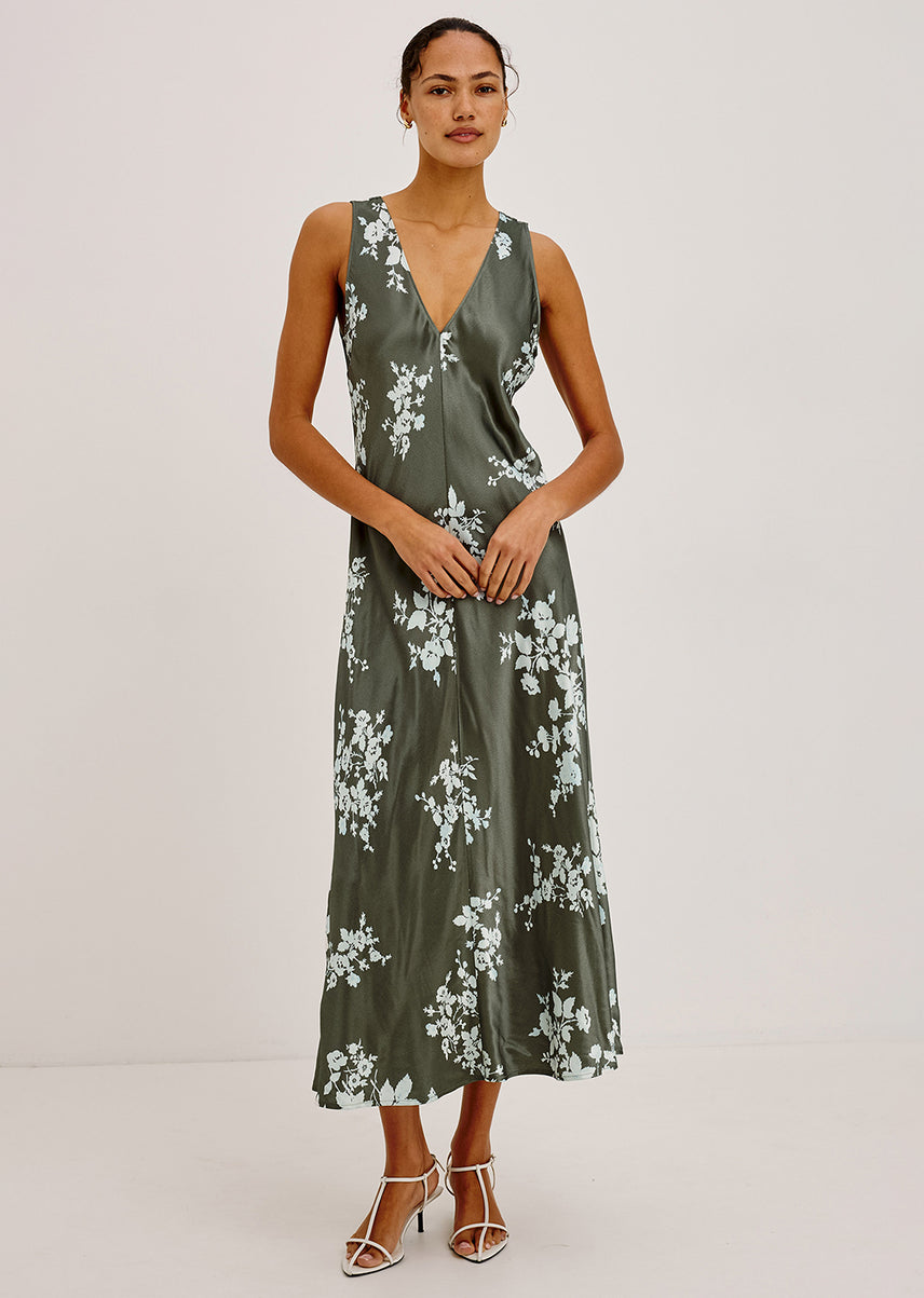 Woman wearing a green maxi satin dress with white detailing