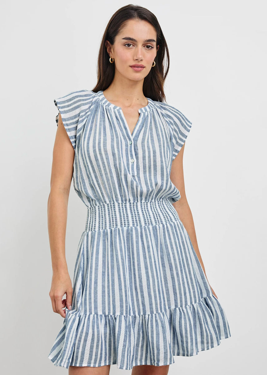 Woman wearing a blue and white striped dress against a plain background