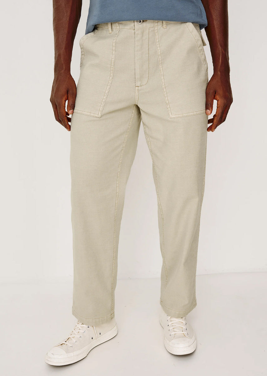 Man wearing beige pants and white sneakers on a white background