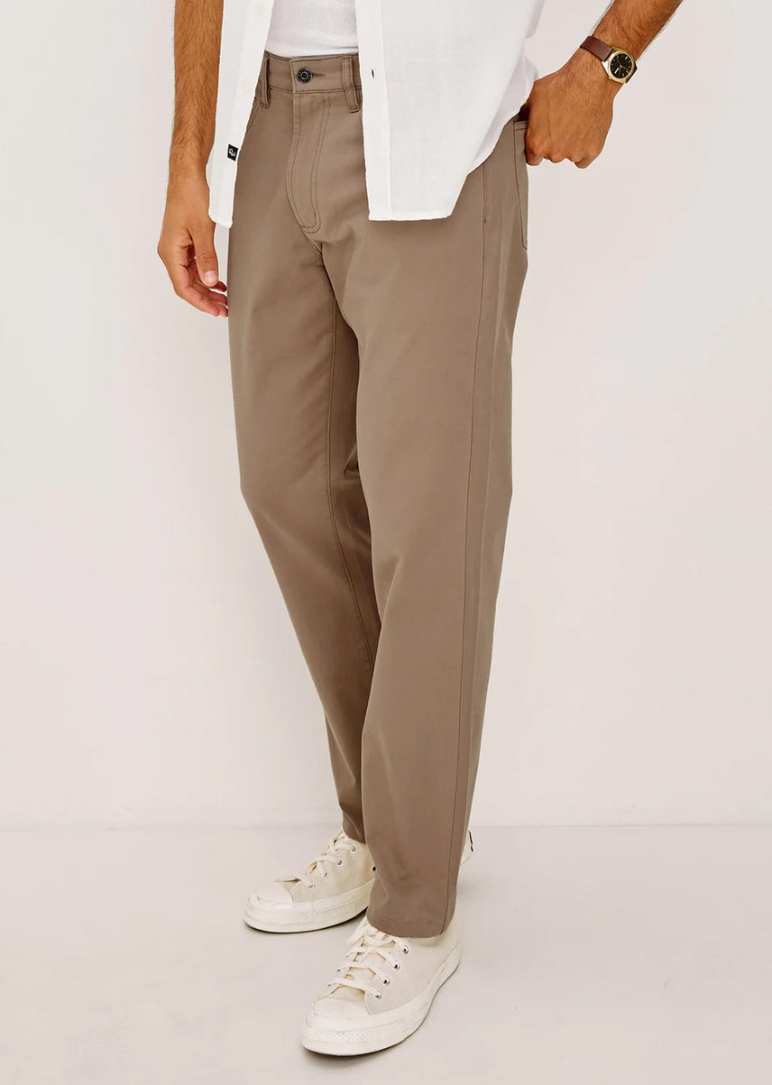 Man wearing brown neutral pants and white shoes