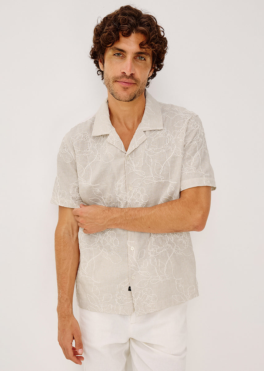 Man wearing a beige shirt with white pants