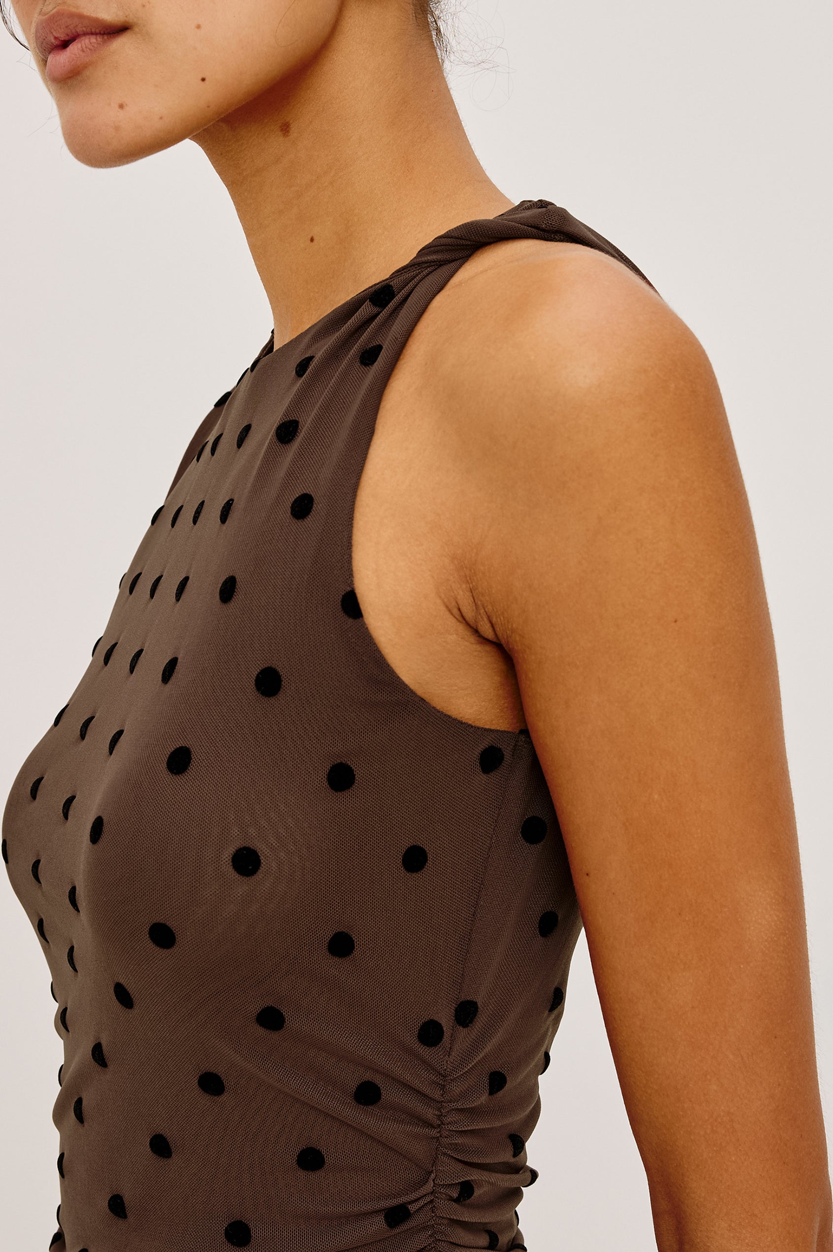 Daija Midi Dress in Self-Lined Mesh With High Neckline, Fitted Bodice, Side Waist Ruching, Bias Cut Skirt, and Asymmetric Hem in Chocolate Polka Dot Colorway - Upper Body Side View Featured on Model