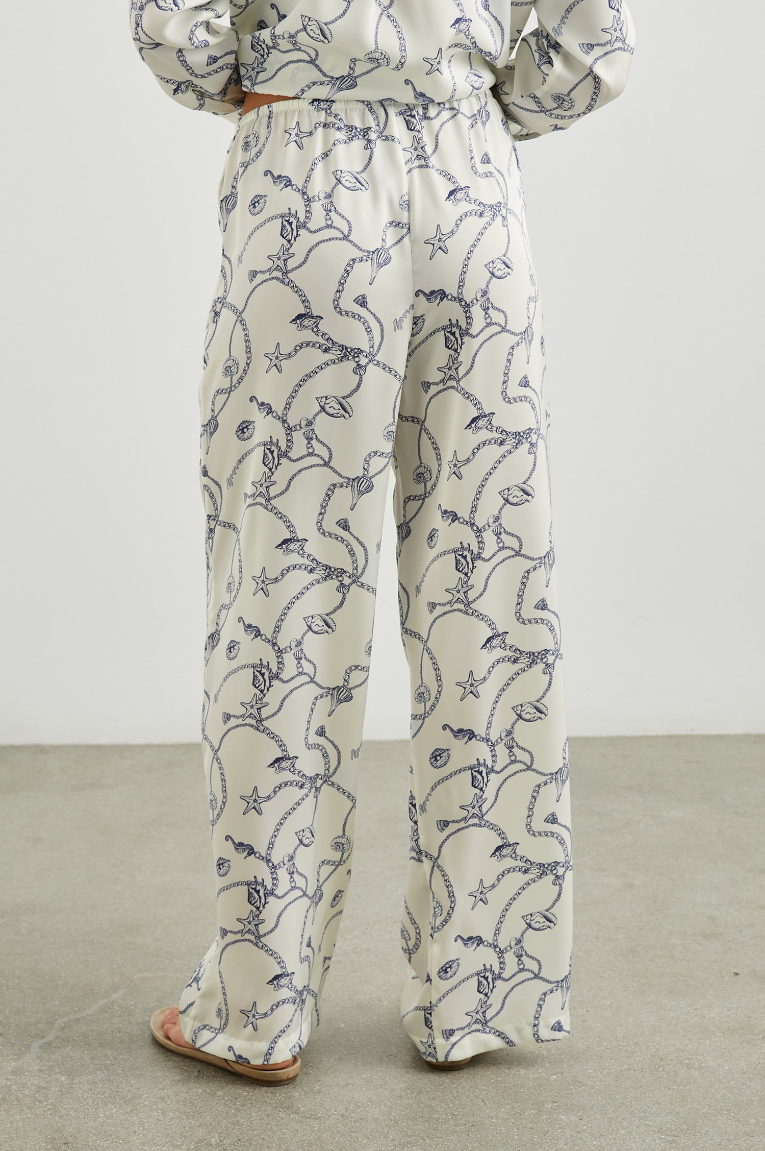 Damini Pants with a Drawstring Waist and Two Front Pockets in Nautical Chain Colorway, with a blue Nautical pattern on white - Back View Featured on Model