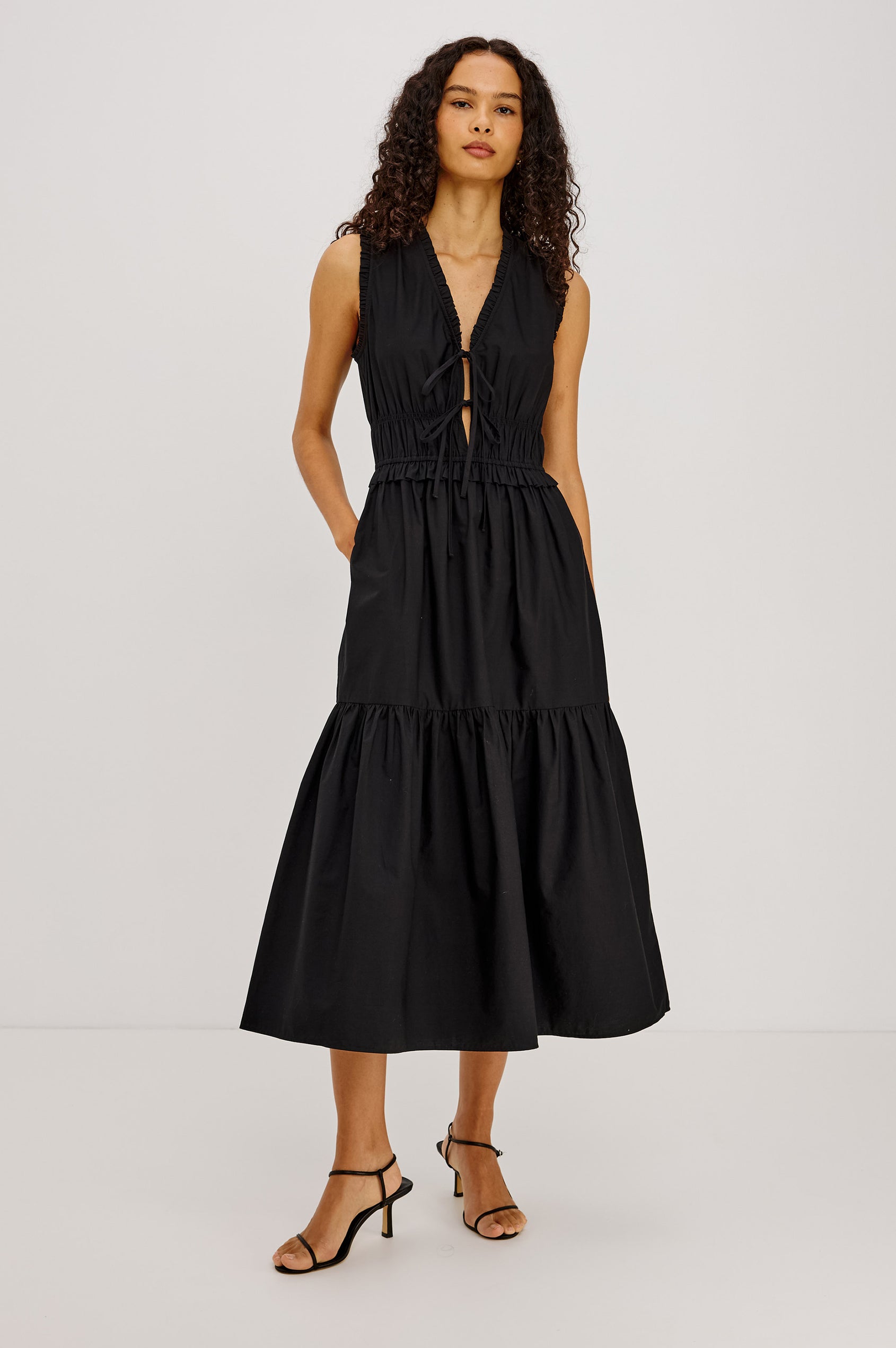 Dana Midi Dress in Cotton Poplin With Deep V-Neck and Center-Front Ties, Laddered Elastic Waist, Fully Lined Tiered Skirt, On-Seam Side Pockets, and Ruffle Trim in Black Colorway - Full Body Front View Featured on Model
