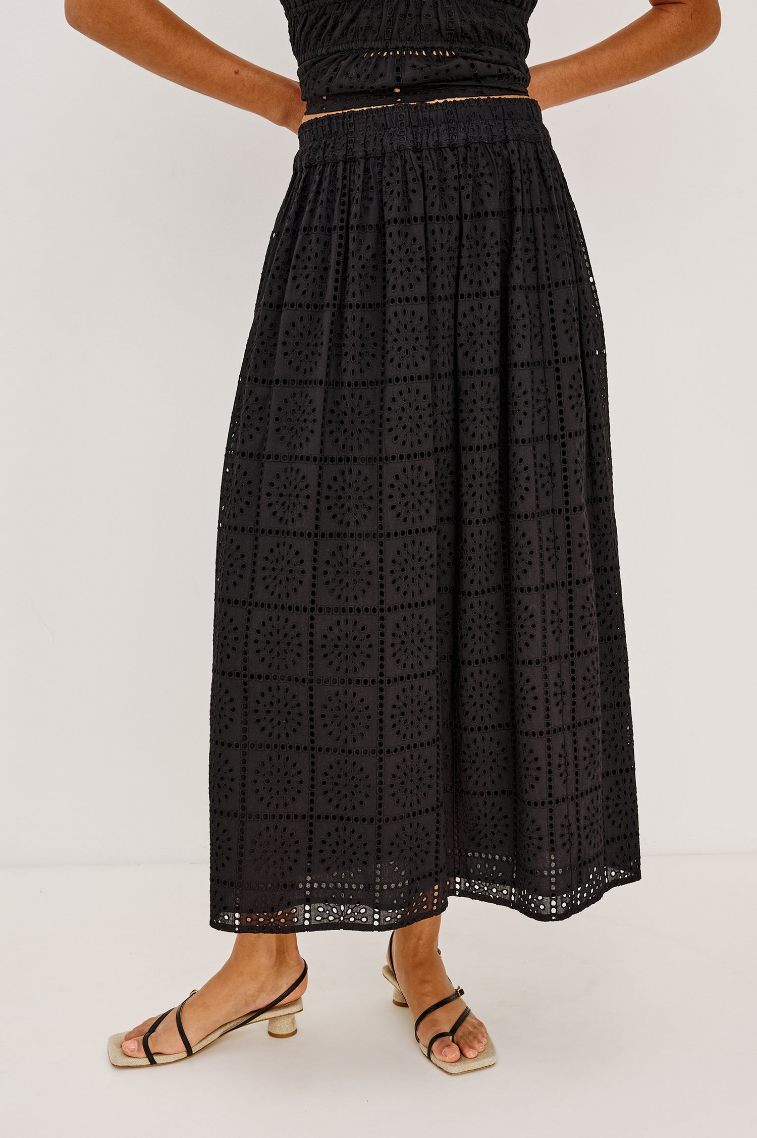 Dax A-Line Maxi Skirt With Grid and Floral Cutwork Embroidery, Elastic Waistband, and is Fully Lined in Black Grid Embroidery Embroidery Colorway - Lower Body Front View Featured on Model