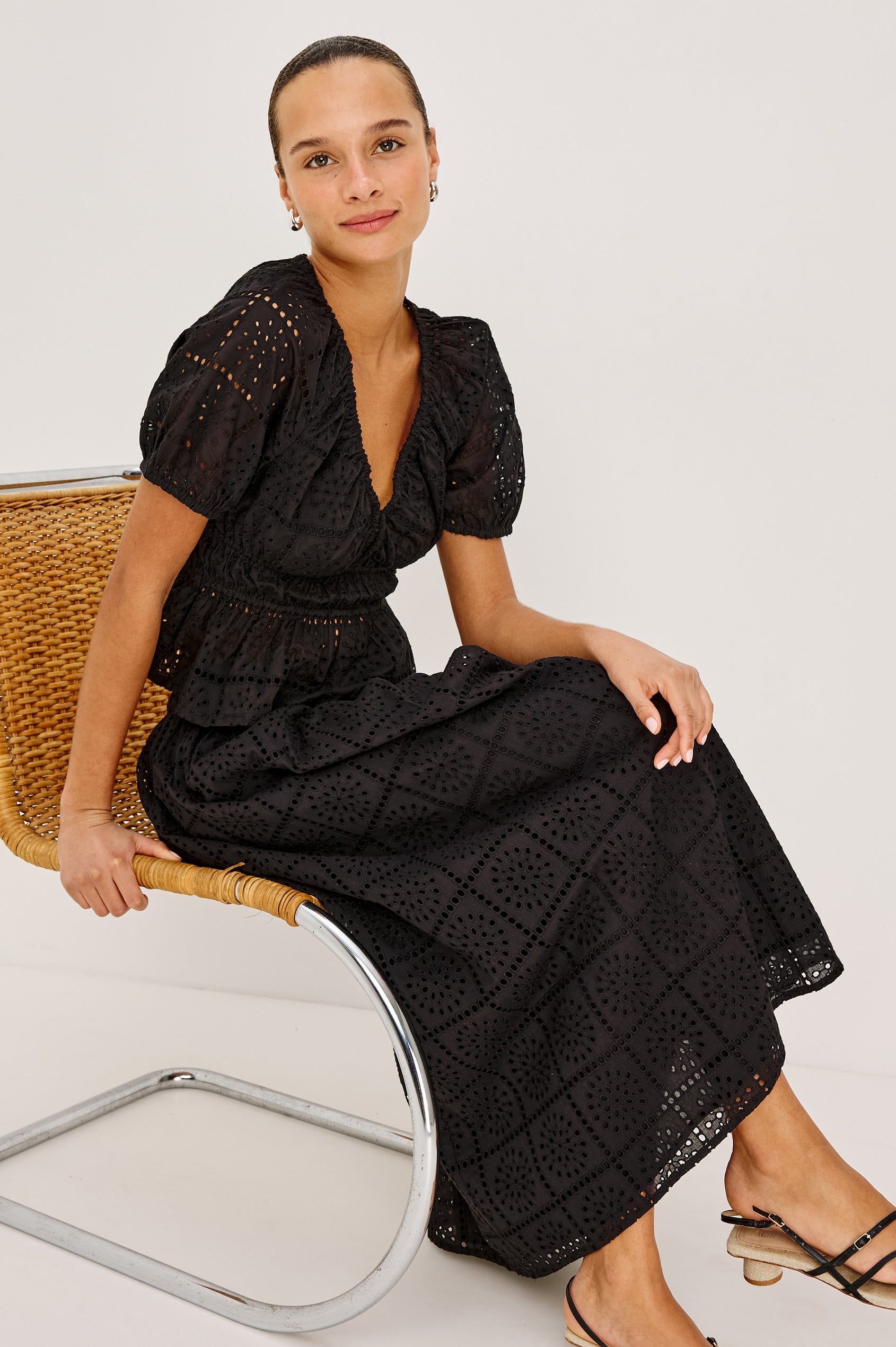 Dax A-Line Maxi Skirt With Grid and Floral Cutwork Embroidery, Elastic Waistband, and is Fully Lined in Black Grid Embroidery Embroidery Colorway - Full Body VIew Featured on Model Sitting