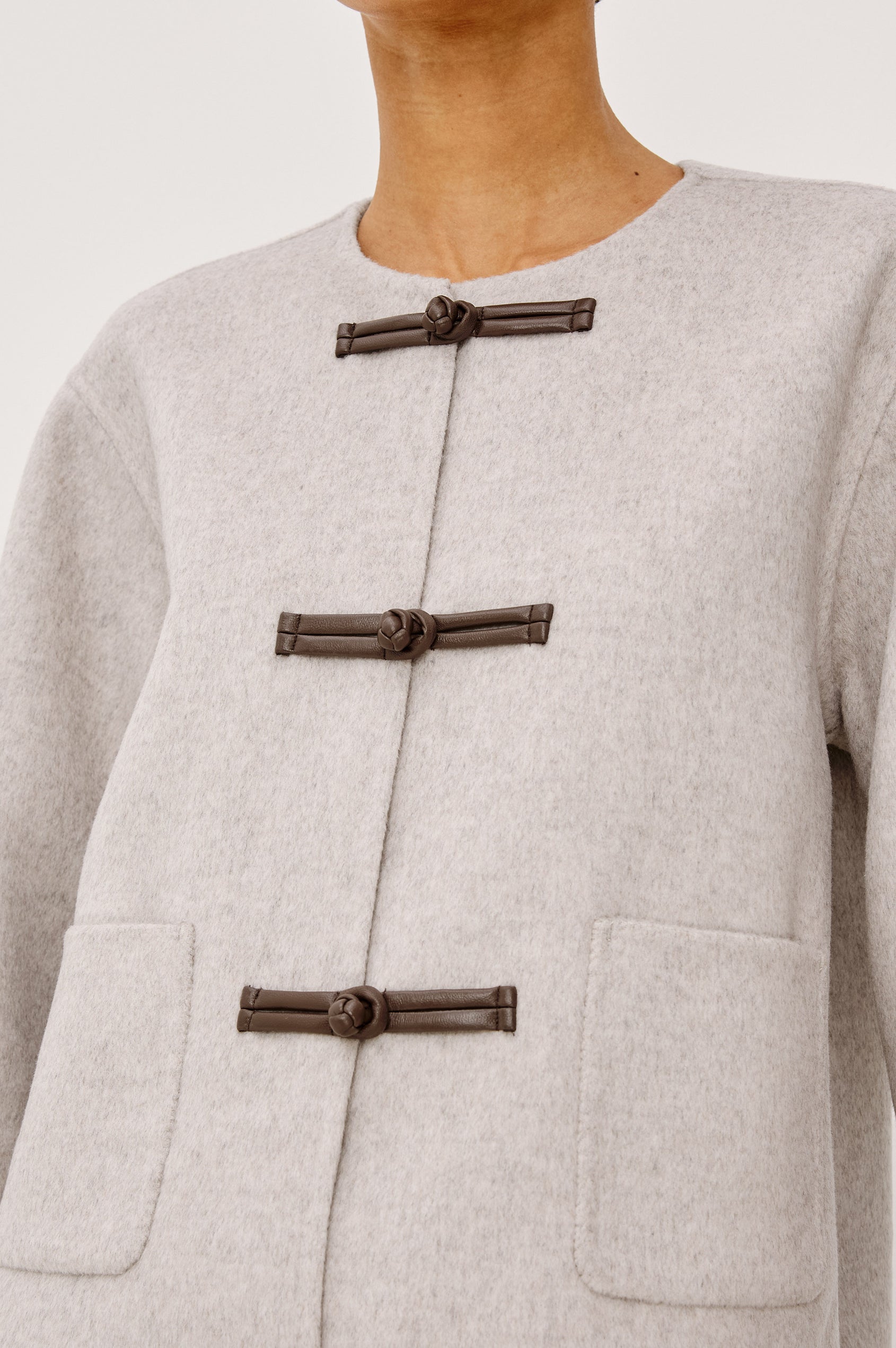 Deidre Jacket in Soft Wool Blend With Collarless Neckline, Boxy Cropped Fit, Front Leather Toggle Closures, Patch Pockets, and Long Sleeves in Heather Oat Colorway - Upper Body Front View Featured on Model