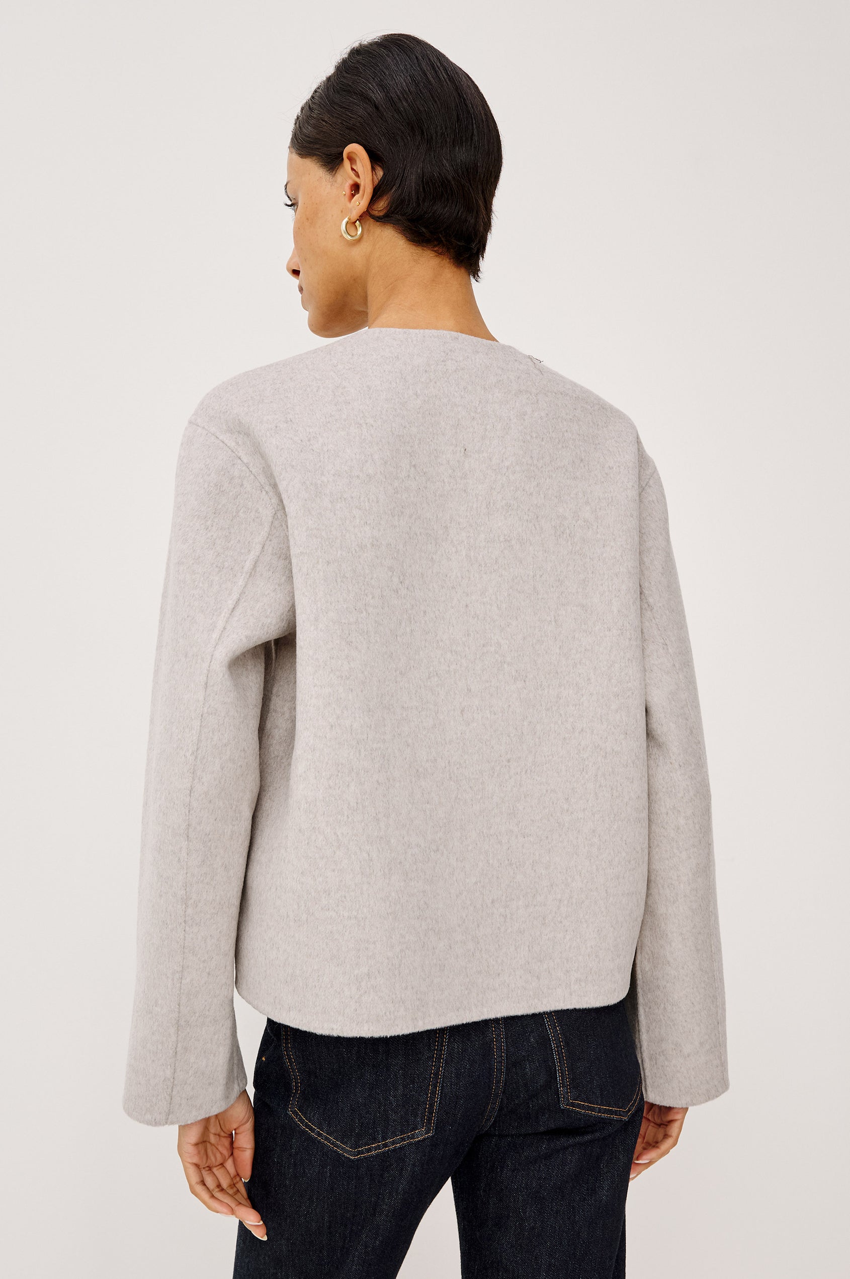 Deidre Jacket in Soft Wool Blend With Collarless Neckline, Boxy Cropped Fit, Front Leather Toggle Closures, Patch Pockets, and Long Sleeves in Heather Oat Colorway - Upper Body Back View Featured on Model