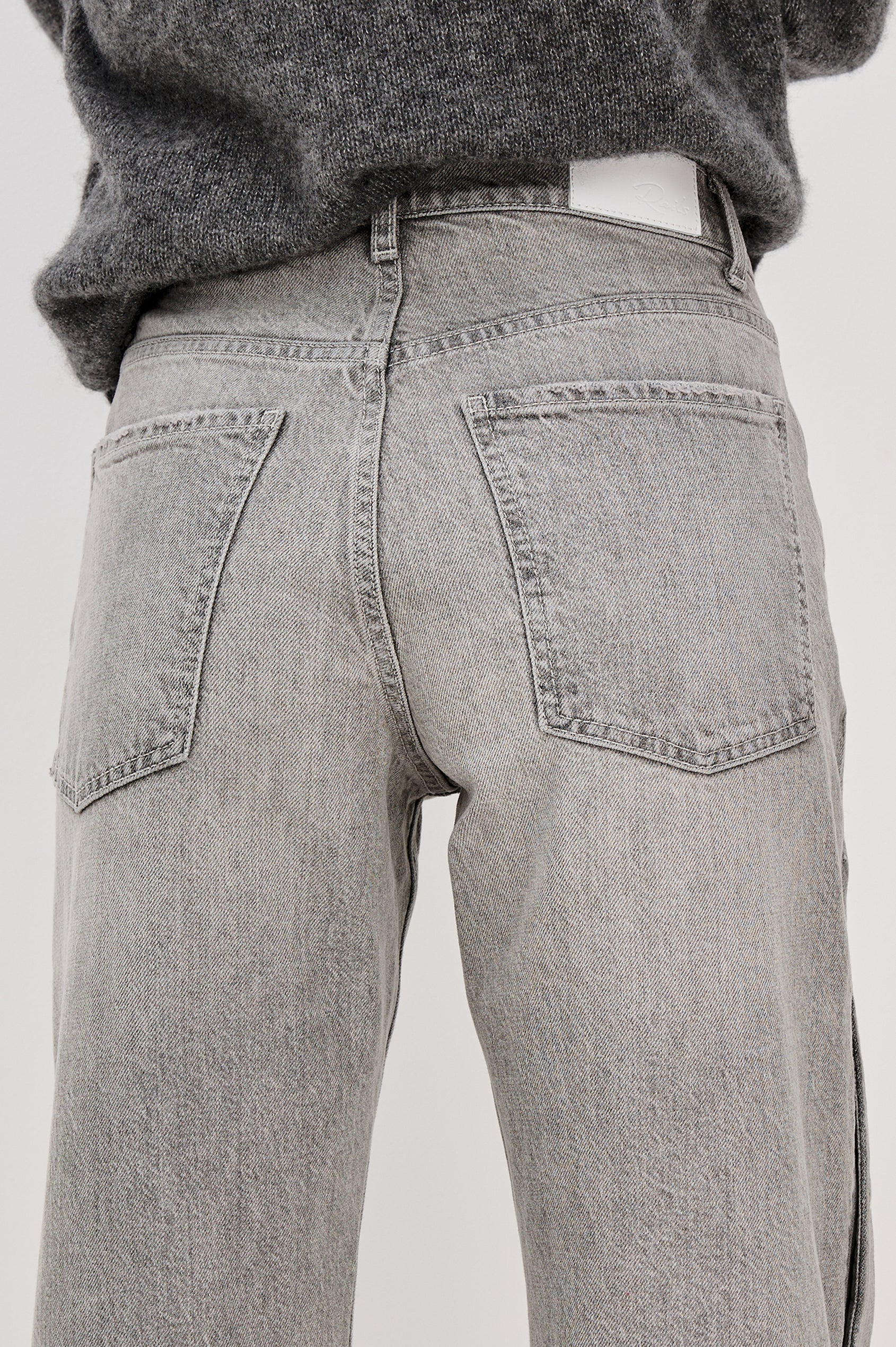 Del Mar low slung baggy boyfriend 5-pocket jean with silver metal studs on side seams and a slit at hem in a grey wash Stone Grey - back detail view featured on model.