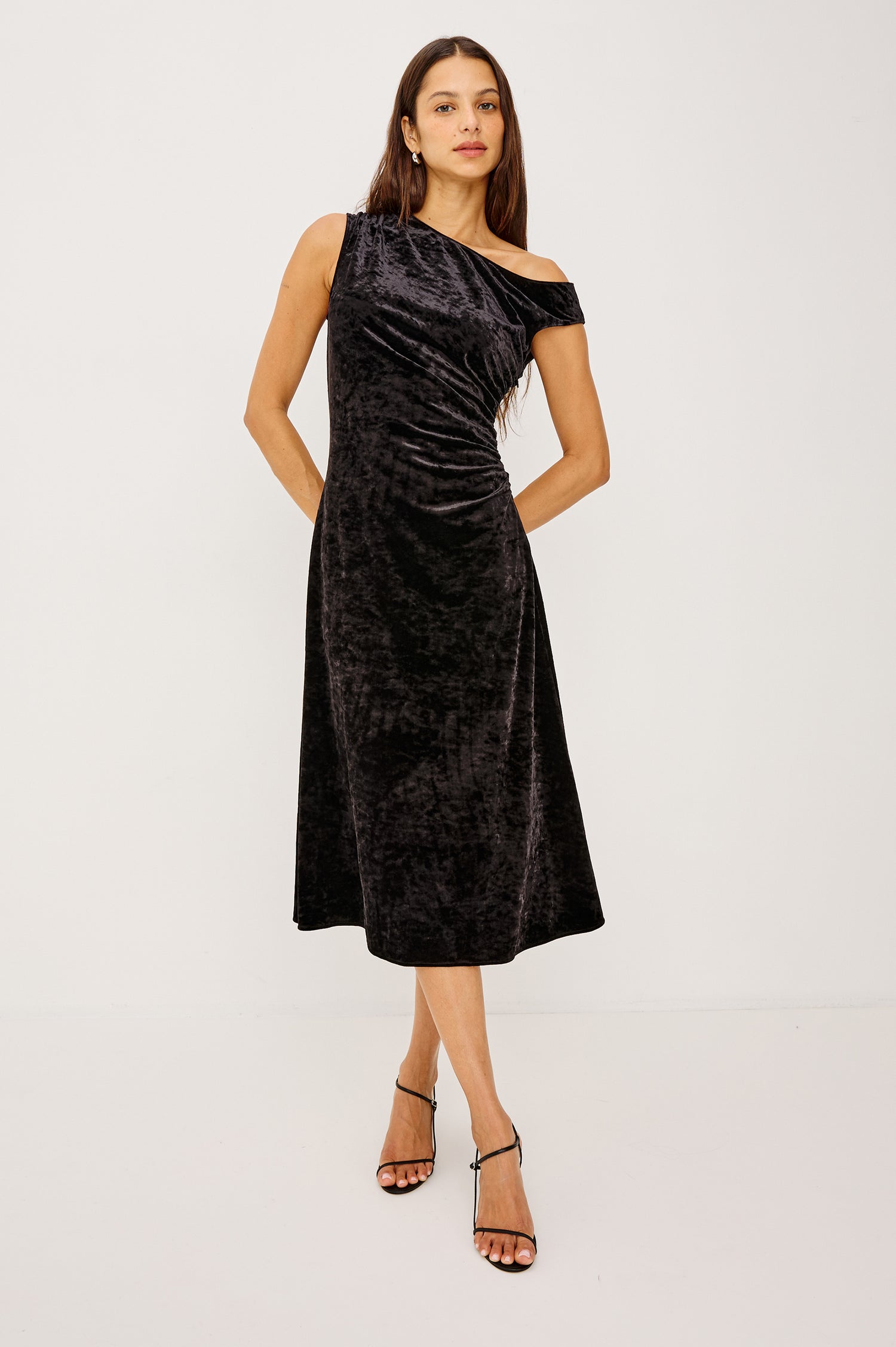 Delores Midi Dress in Stretch Velvet With Off-Shoulder Neckline, Side Shirring, A-Line Skirt in Black Colorway - Full Body Front View Featured on Model