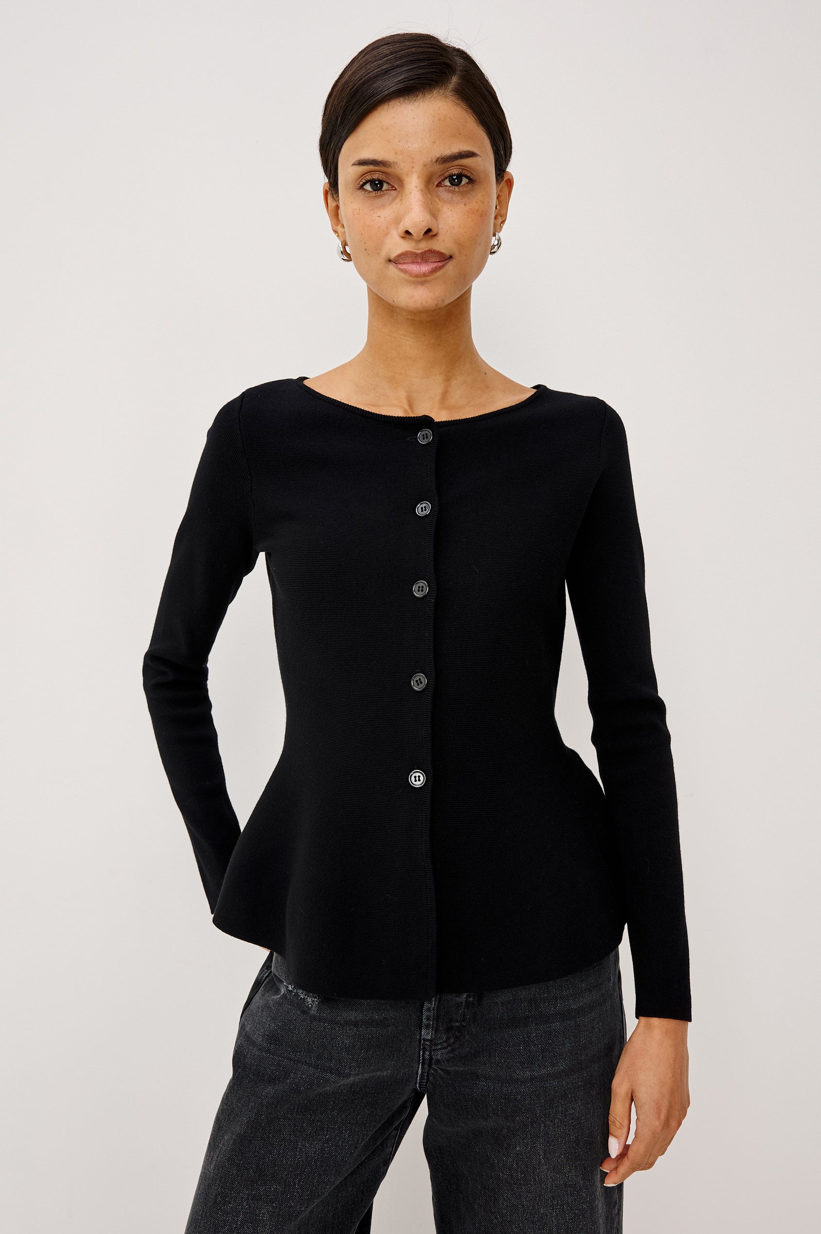 Diane Cardigan in Fine-Gauge Knit With Fitted Body, Peplum Hem, Round Neckline, and Center Front Placket With Self-Covered Buttons in Black Colorway - Upper Body Front View Featured on Model