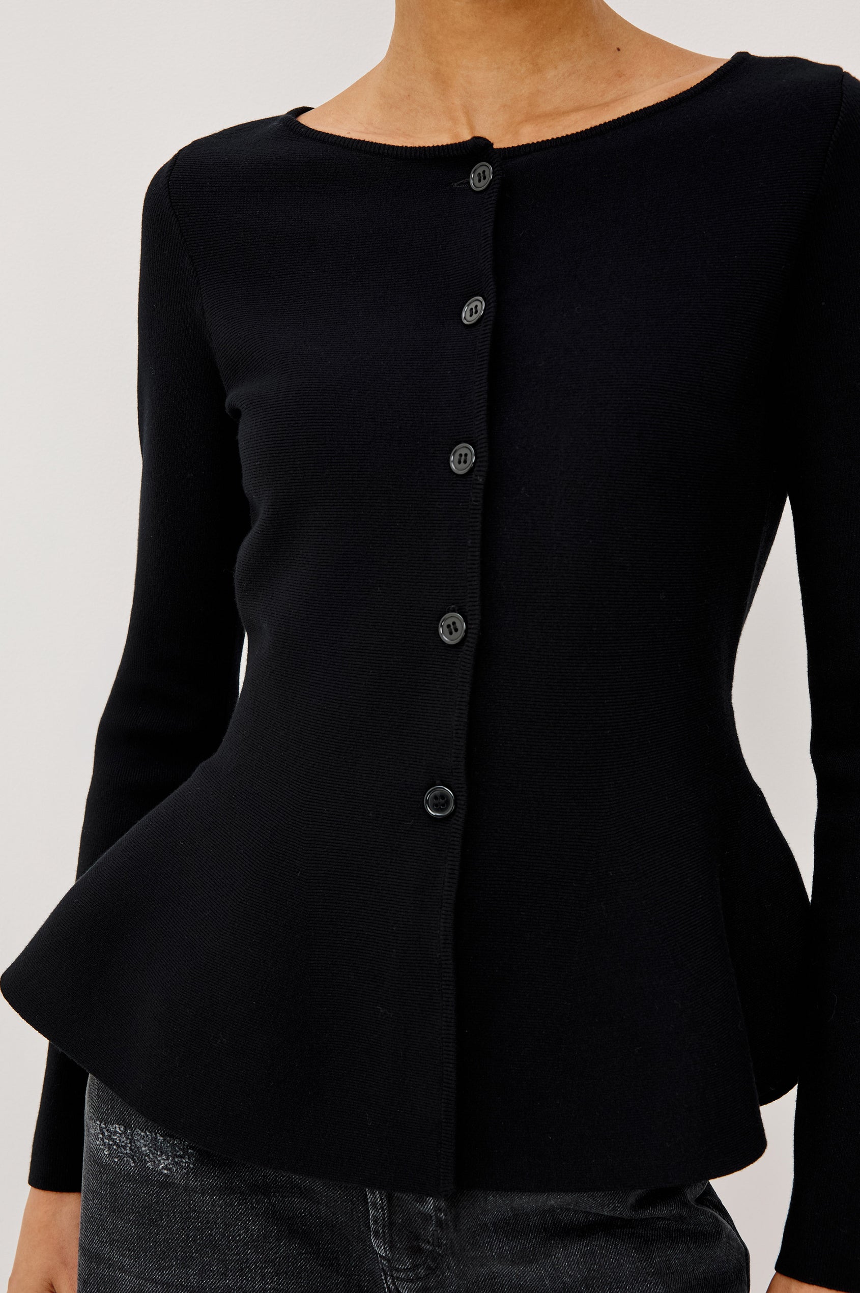 Diane Cardigan in Fine-Gauge Knit With Fitted Body, Peplum Hem, Round Neckline, and Center Front Placket With Self-Covered Buttons in Black Colorway - Upper Body Front View Featured on Model