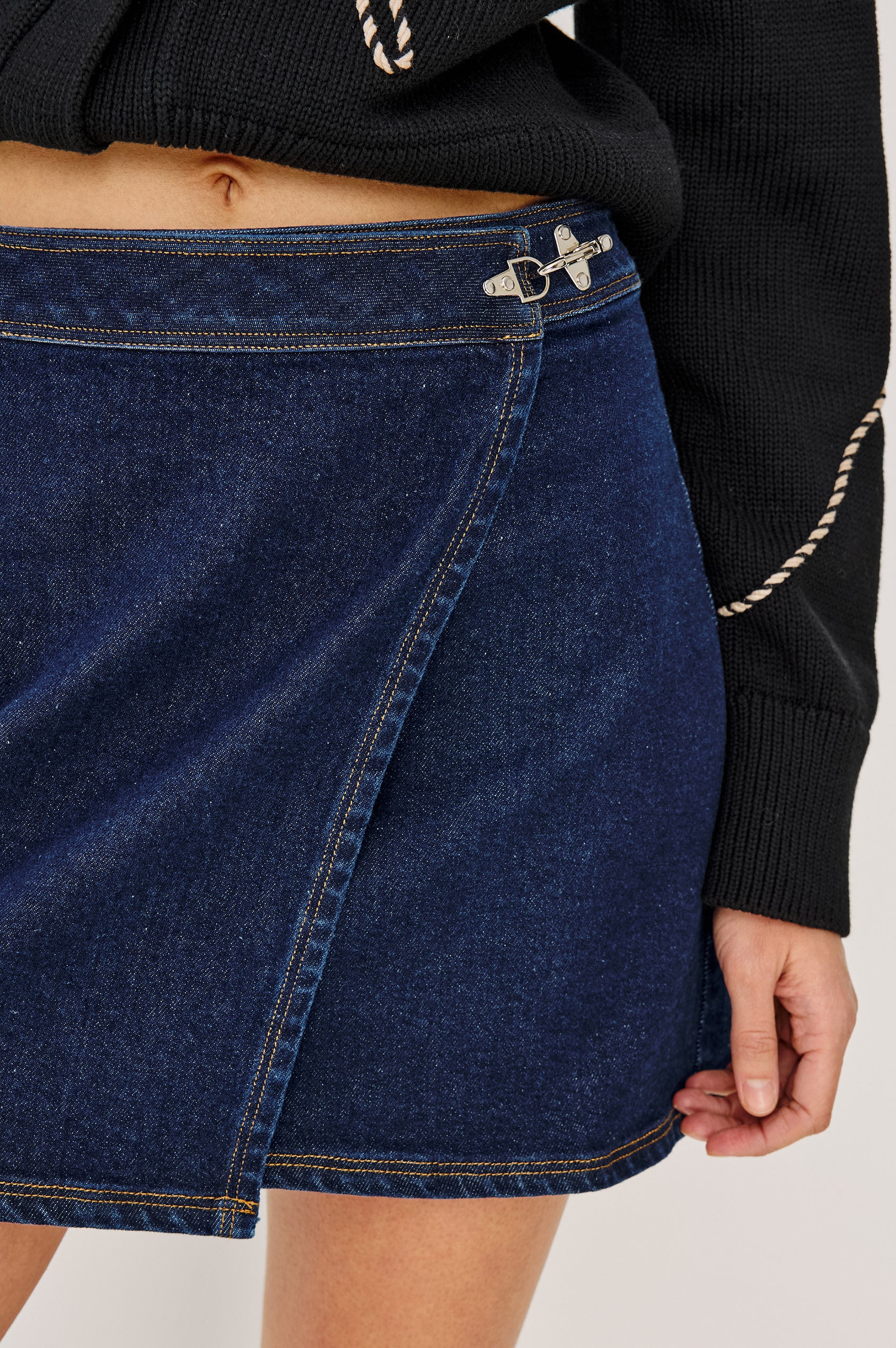 Dillon Mini Skirt in Midweight Denim With Mid-Rise, Asymmetric Wrap Design, Toggle Closure at Side Waist, Contrast Topstitching, and Utility Patch Pocket in Rinse Indigo Colorway - Lower Body Front View Featured on Model
