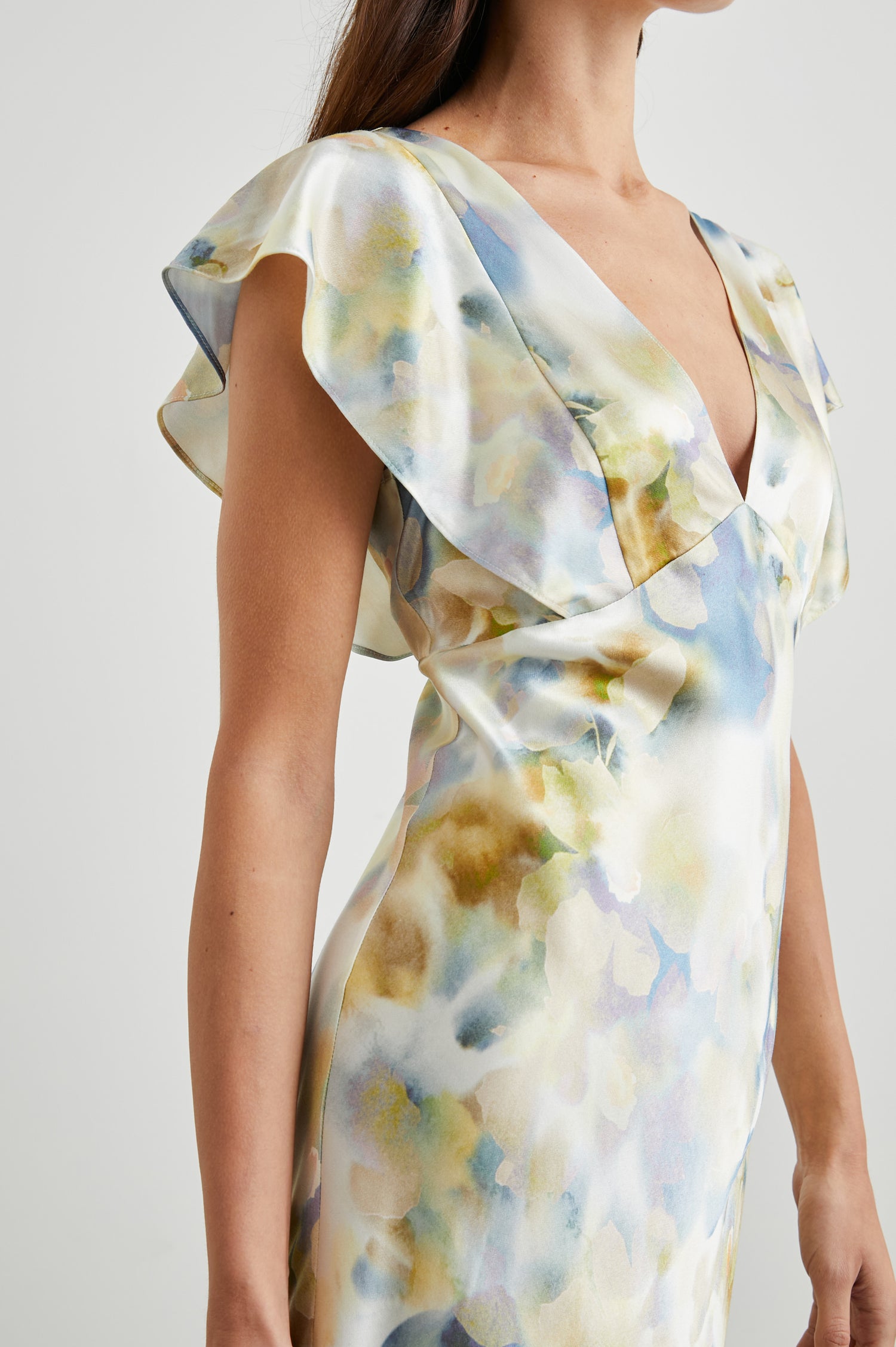 Dina Short-Sleeve Midi Dress with a Deep V Neck, Flutter Sleeves, and a Thigh Side Slit in Diffused Blossom Colorway, Flowers in Gold and Creams on Blue - Front View Featured on Model