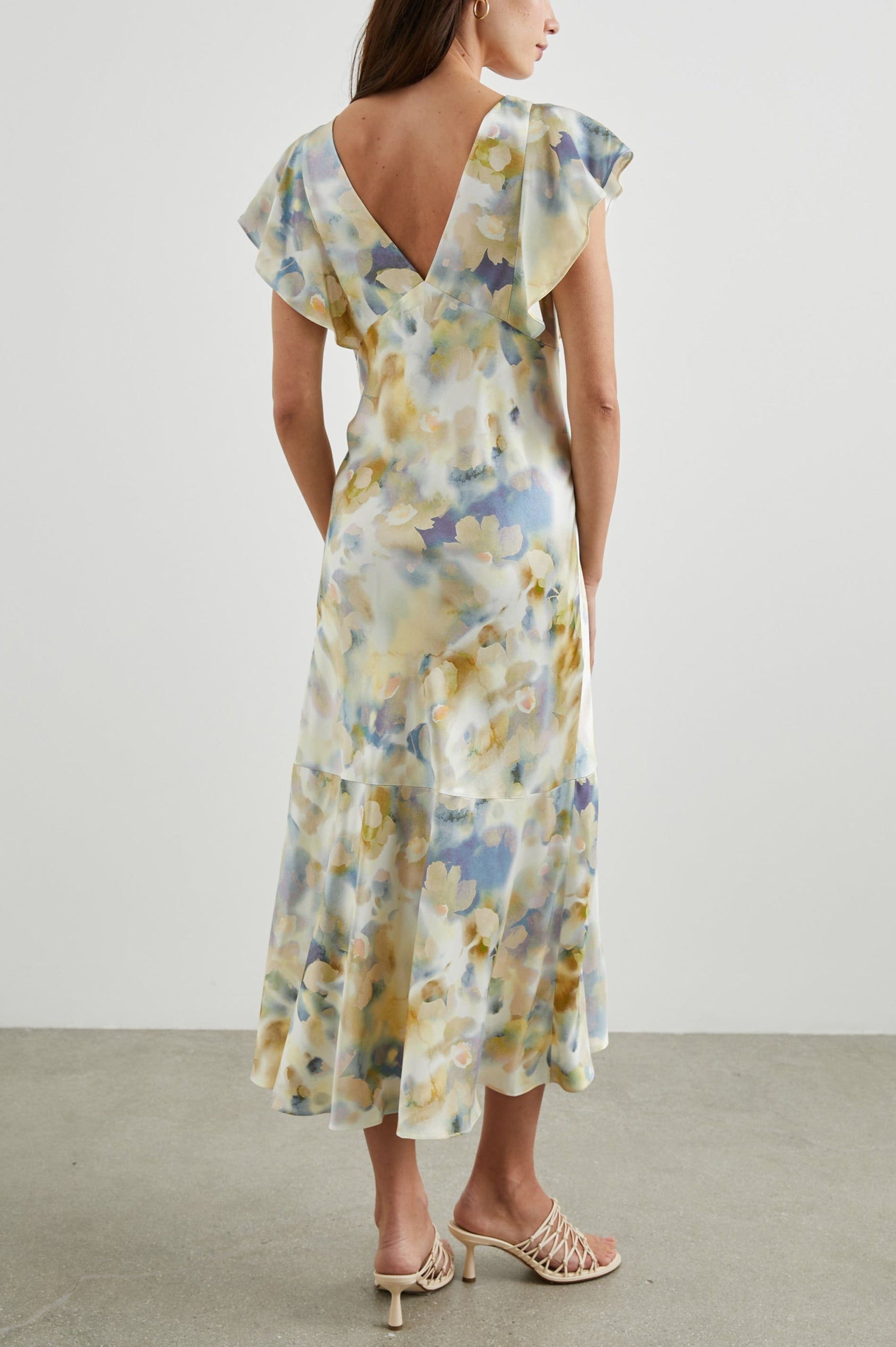 Dina Short-Sleeve Midi Dress with a Deep V Neck, Flutter Sleeves, and a Thigh Side Slit in Diffused Blossom Colorway, Flowers in Gold and Creams on Blue - Front Back Body View Featured on Model