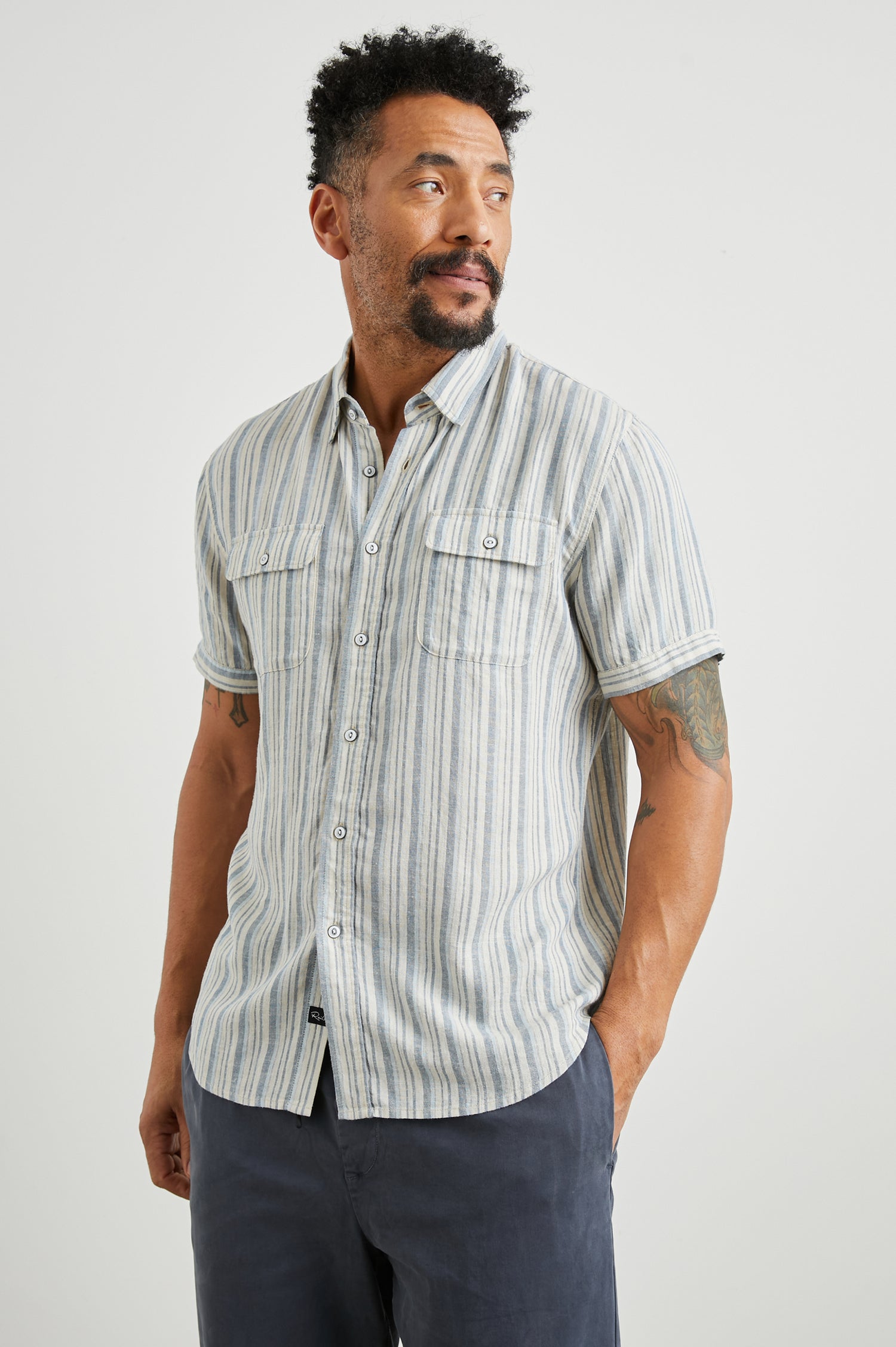 Donnie Short-Sleeve Button Up with Two Chest Button Flap Pockets in Blue Cap Range Colorway, Vertical Stripes in Muted Blues and Cream - Front View Featured on Model