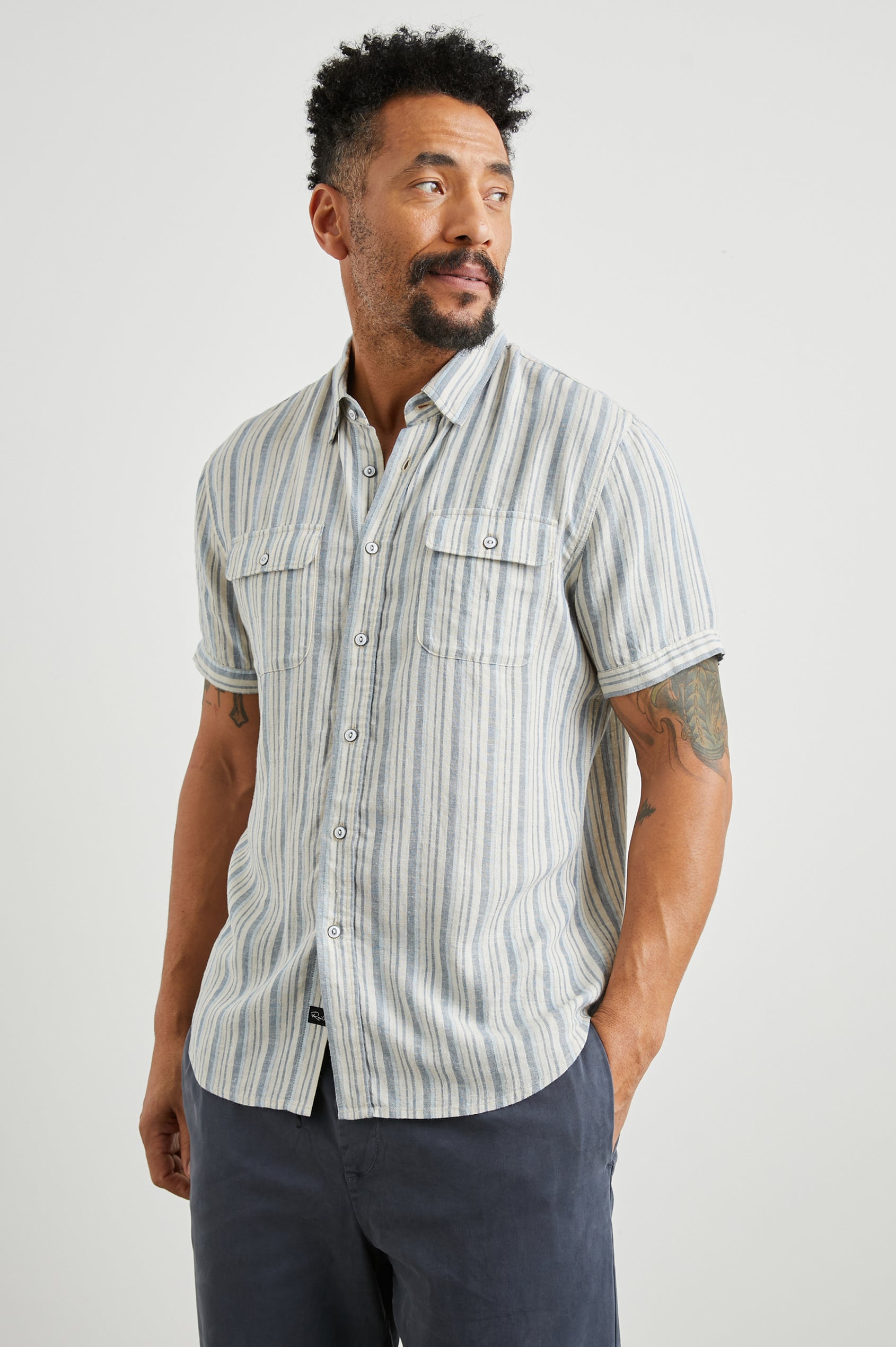 Donnie Short-Sleeve Button Up with Two Chest Button Flap Pockets in Blue Cap Range Colorway, Vertical Stripes in Muted Blues and Cream - Front View Featured on Model