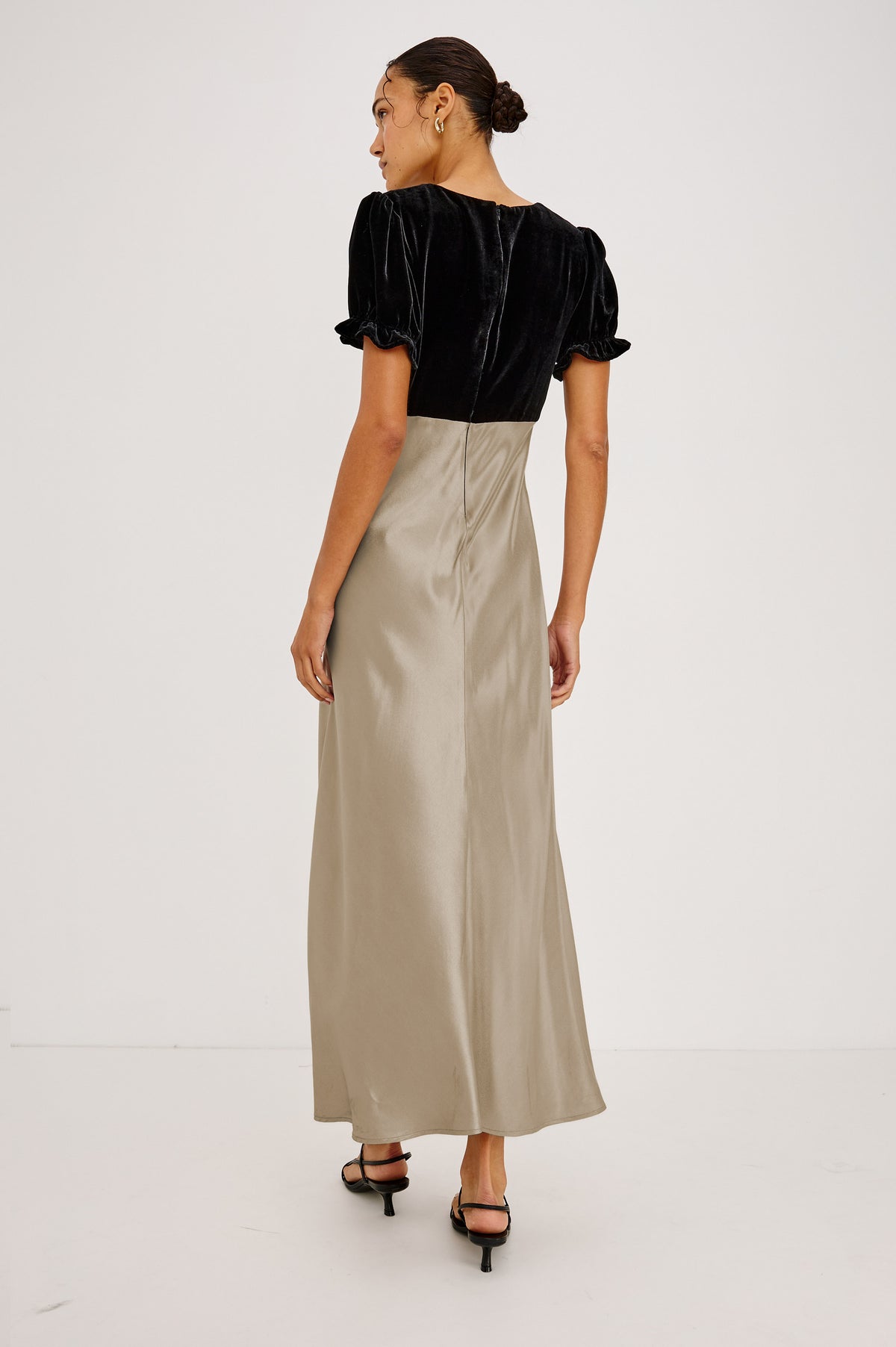 Dory Maxi Dress With V-Neckline and Adjustable Center Bust Ties, Short Puff Sleeves, Satin Back Crepe Skirt, and Back Zipper Closure in Mink Colorway - Back Full Body View Featured on Model.