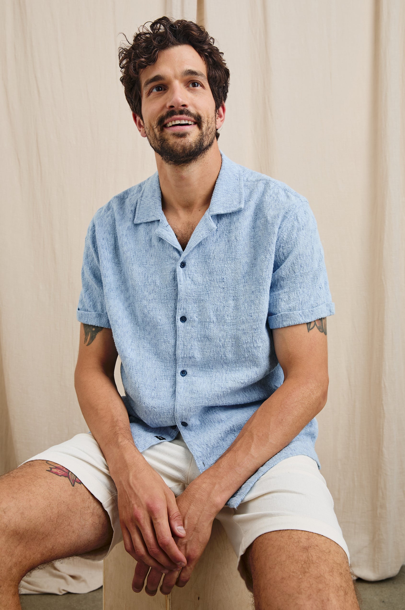 Dresden Short Sleeve Button Up with Rolled Cuffs in Cerulean Ikat Colorway - Front View Featured on Seated Model
