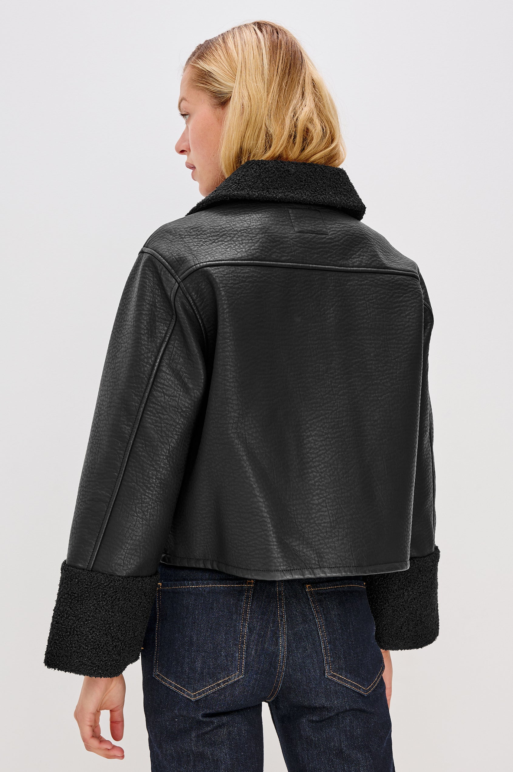 Dria Jacket with Button Closure, Two Front Patch Pockets and Faux Shearling at the Pockets, Cuffs, Collar and Opening in Black Shearling Colorway, Back View Featured on Model 