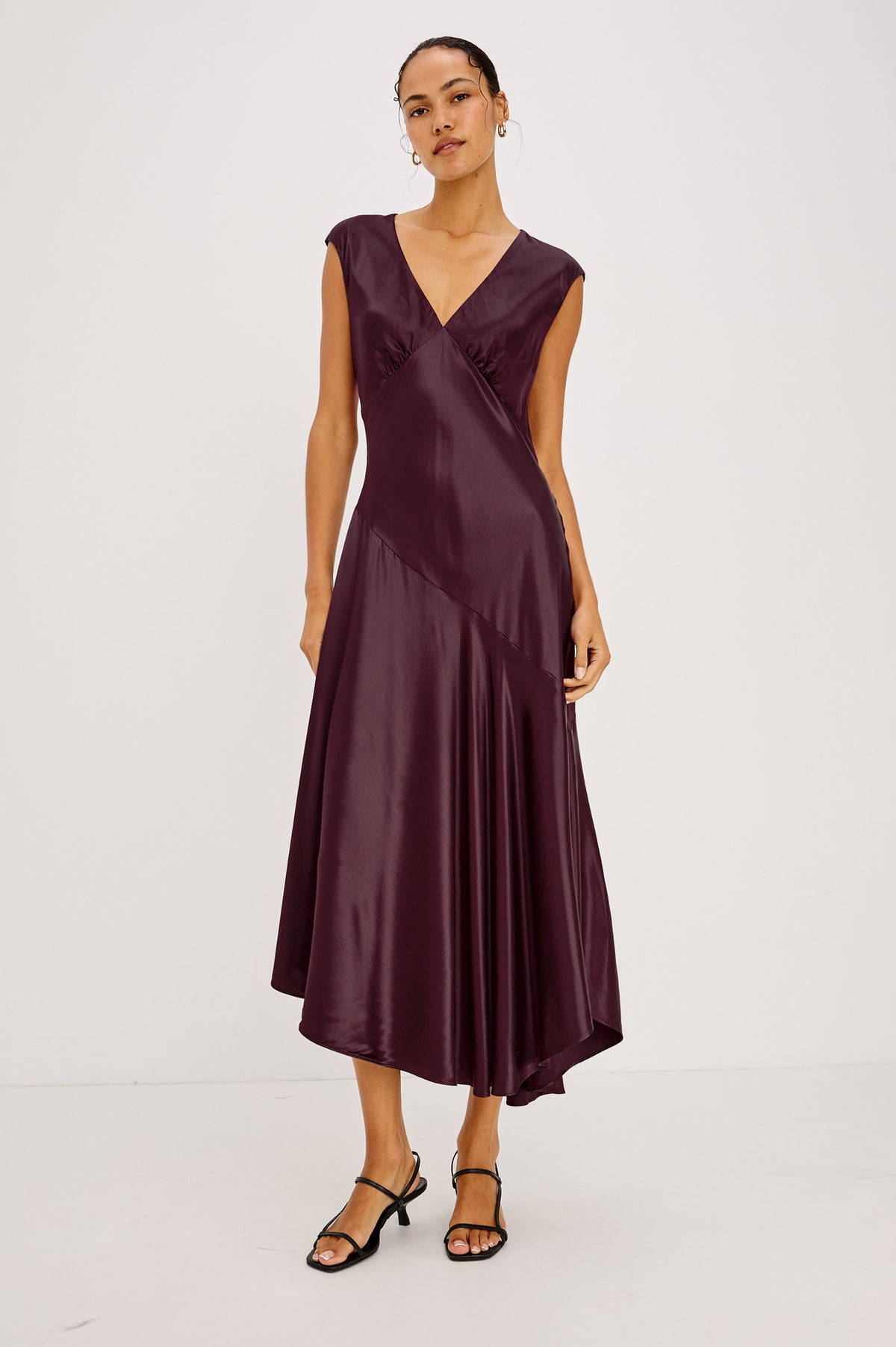 Eleni Midi Dress in Satin-Back Crepe With V-Neckline, Side Zip, Asymmetric Seam, and Handkerchief Hem in Wine Colorway - Front Full Body View Featured on Model.